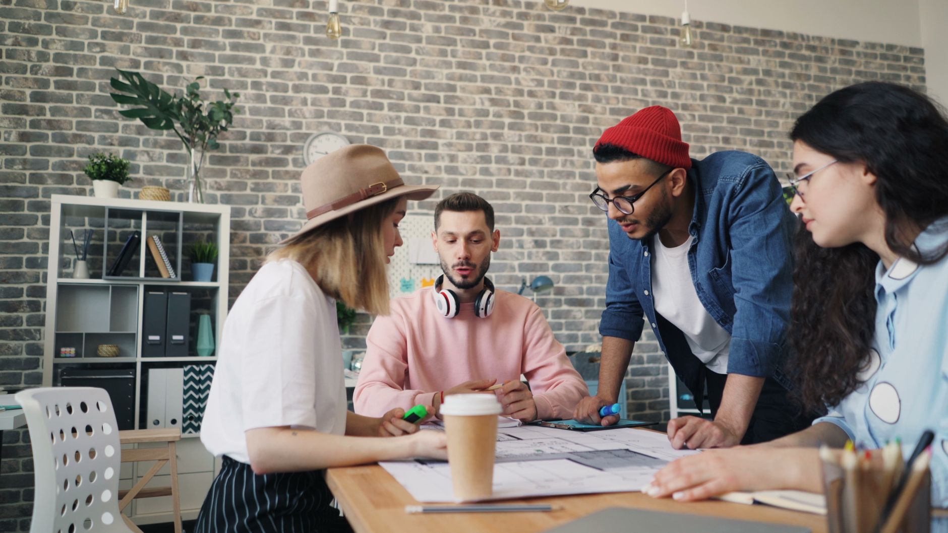 Qualifi Level 3 Diploma in Business Innovation and Entrepreneurship — Young diverse team collaborating in modern office setting, engaged in creative brainstorming session.