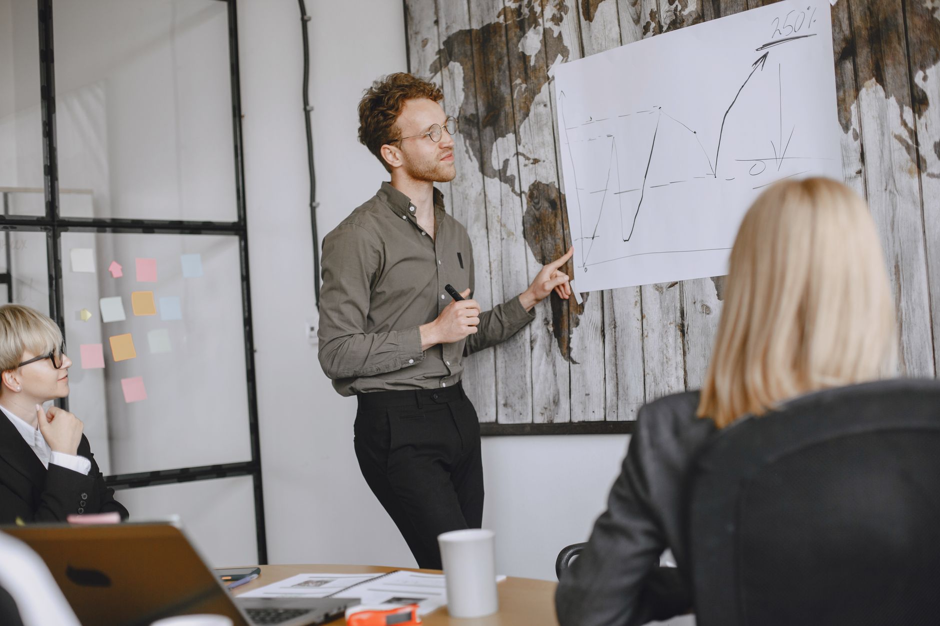 Qualifi Level 4 Diploma in Business Management — A group of professionals engaged in a business meeting with a presentation in a modern office.