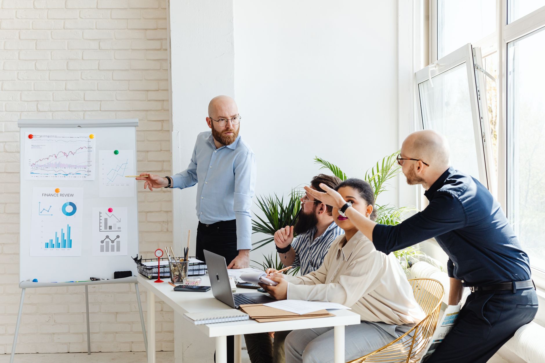 Qualifi Level 5 Diploma in Business Enterprise — A group of professionals engaged in a business meeting, discussing financial graphs on a whiteboard.