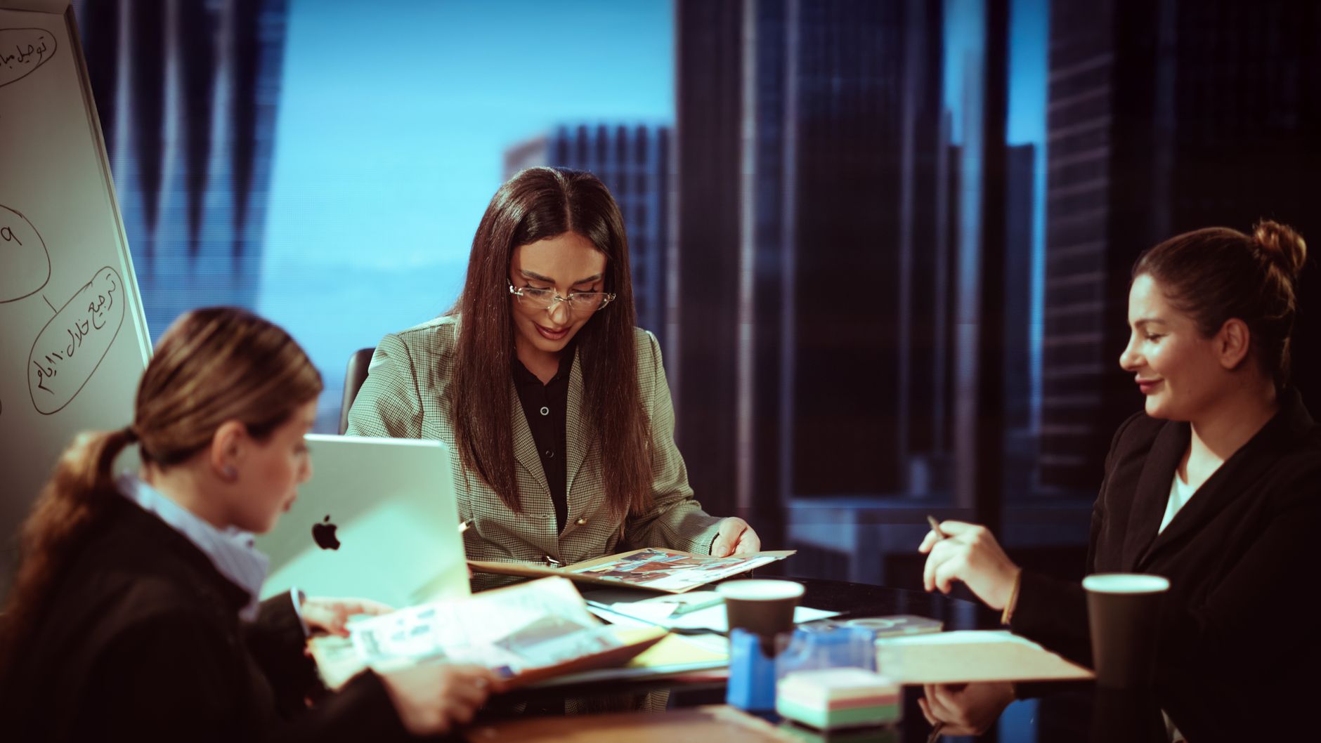 Qualifi Level 6 Diploma in Business Administration — Three businesswomen engaged in a meeting inside a contemporary office.