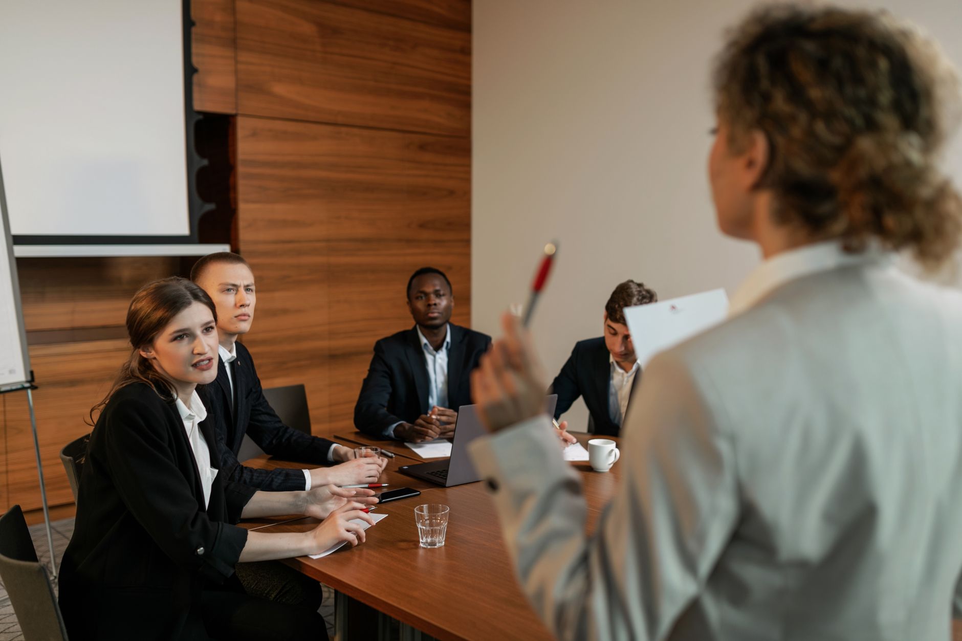 Qualifi Level 6 Diploma in Business Management, Leadership and Innovation — Professional business discussion among diverse colleagues in a modern office setting.