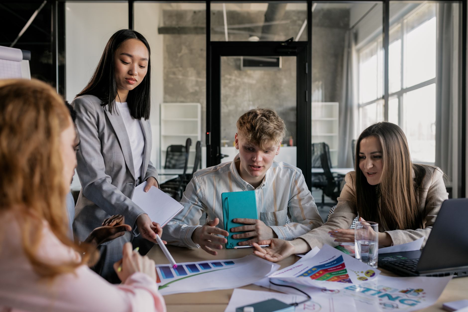 Qualifi Level 7 Diploma in Business Strategy — A diverse group of colleagues having a lively discussion around a conference table in a modern office.