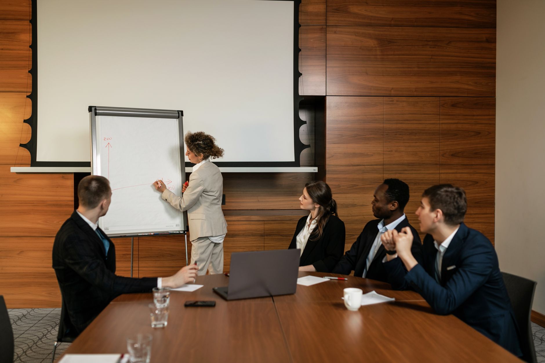 Qualifi Level 7 Diploma in Executive Management — A professional team engaged in a conference room meeting with a presentation.