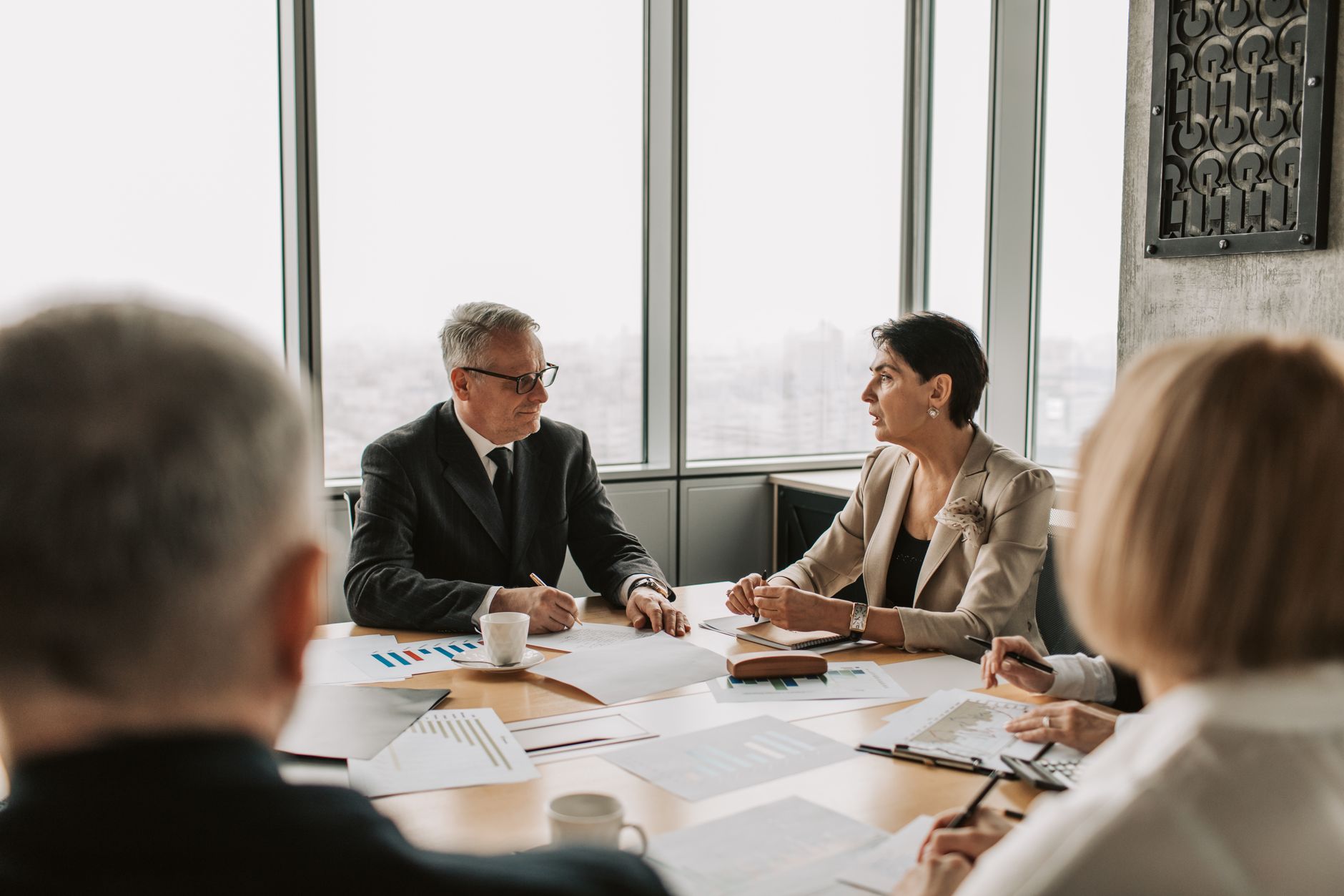 Qualifi Level 8 Diploma in Strategic Management and Leadership — Business professionals engaged in a strategic meeting in a modern office setting with natural light.