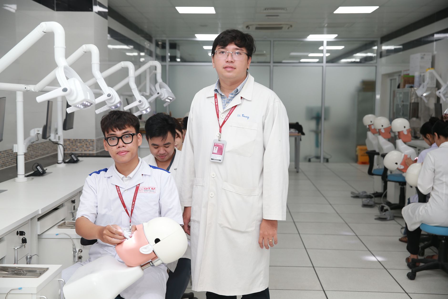 Qualifi Level 3 Diploma in Health and Social Care — Dental students practicing on mannequins under supervision in a clinical lab setting.