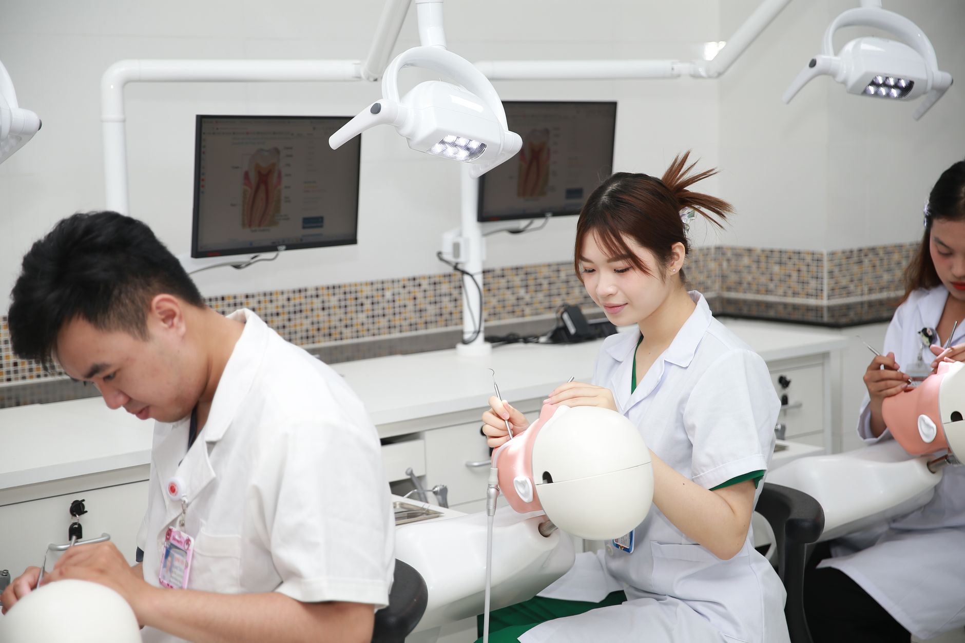 Qualifi Level 3 Extended Diploma in Health and Social Care — Dental students practicing procedures on training models in a classroom setting.
