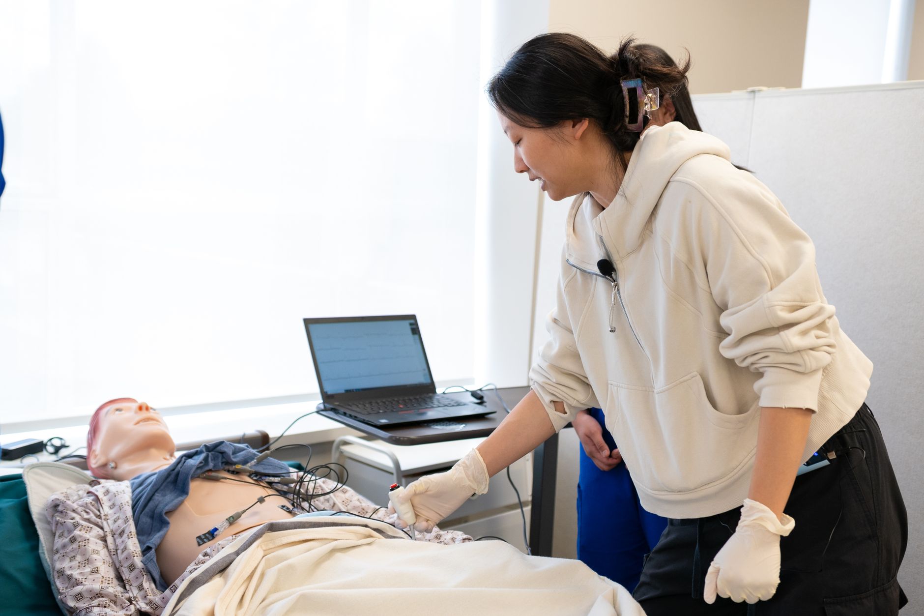 Qualifi Level 4 Diploma in Health and Social Care — Medical student practicing with a simulation mannequin in a classroom setup, focusing on hands-on training.