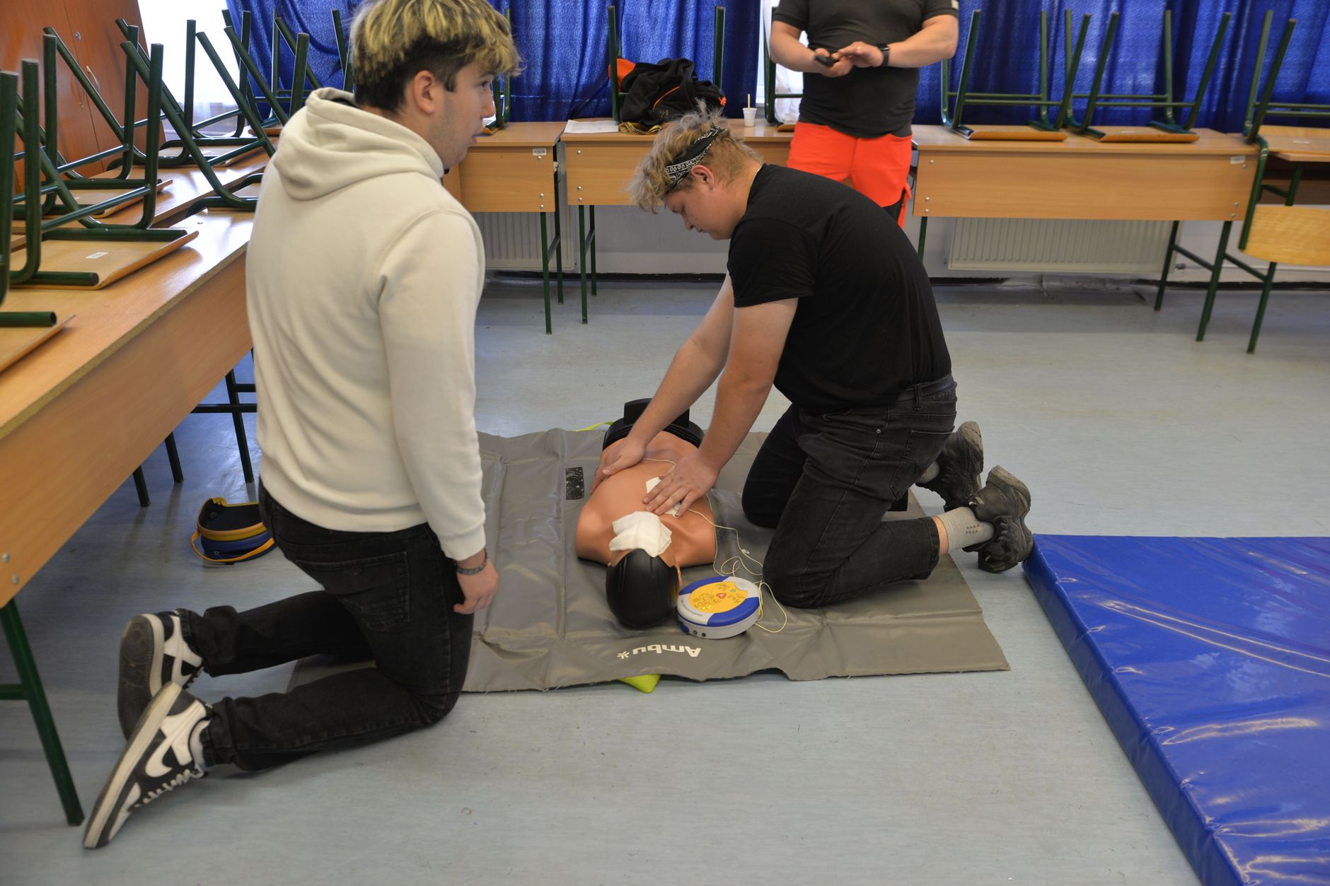 Qualifi Level 6 Diploma in Health and Safety Management — CPR training session with a dummy in a classroom environment.