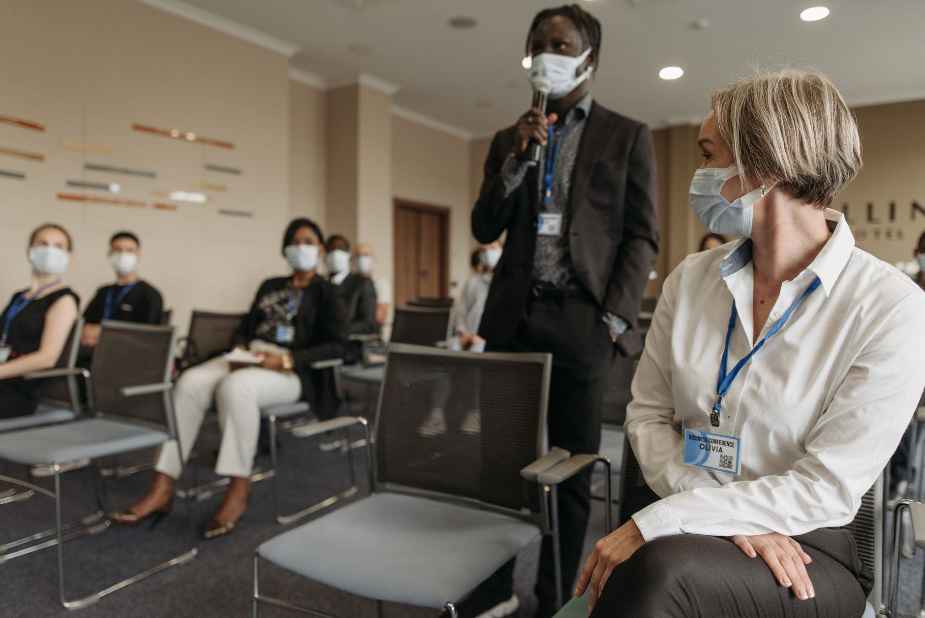 Qualifi Level 6 Diploma in Occupational Health and Safety Management — Diverse group of professionals in a business meeting wearing masks for safety.