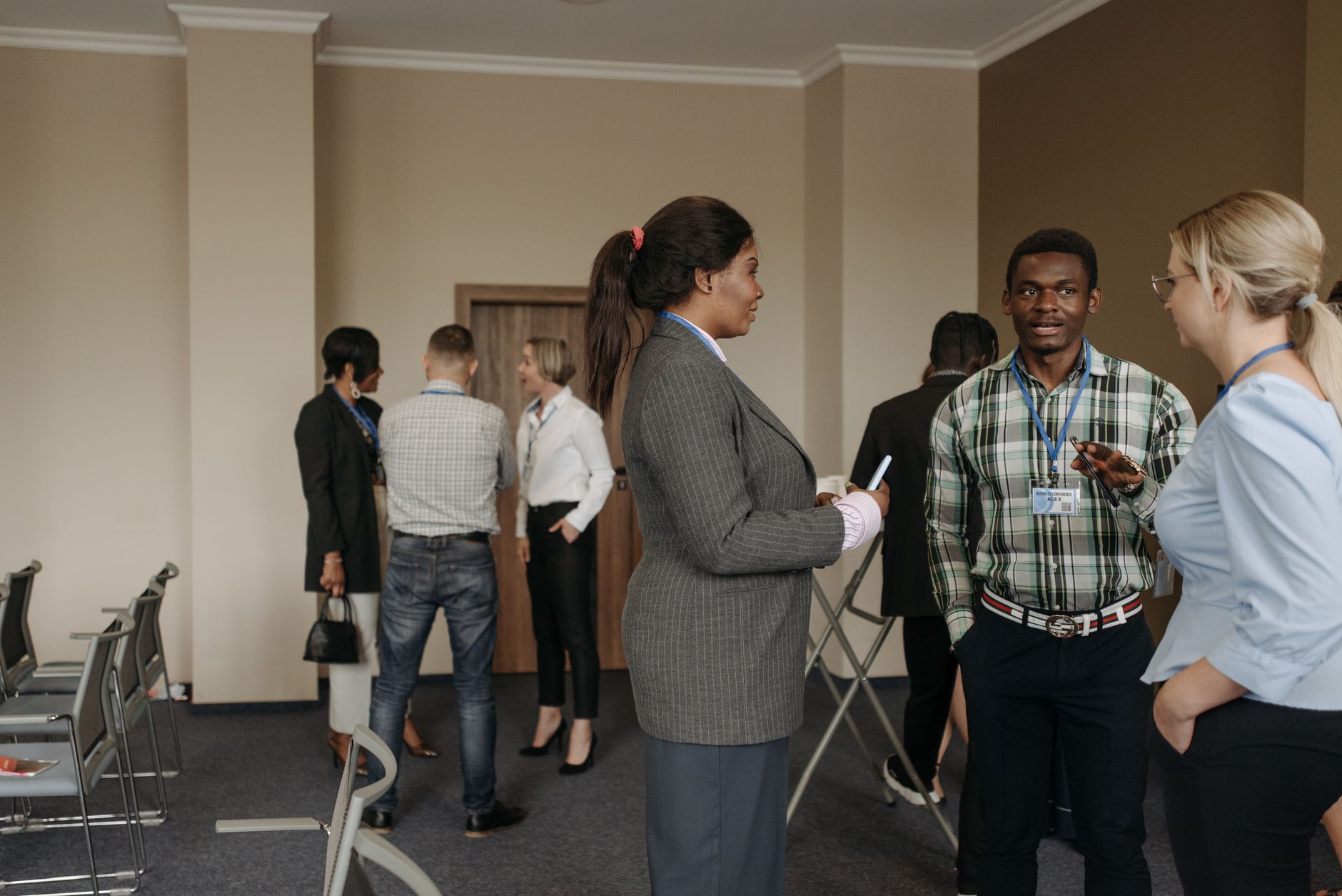 Qualifi Level 7 Diploma in Human Resource Management — Professionals engaging in conversation at a diverse business conference with corporate attire indoors.