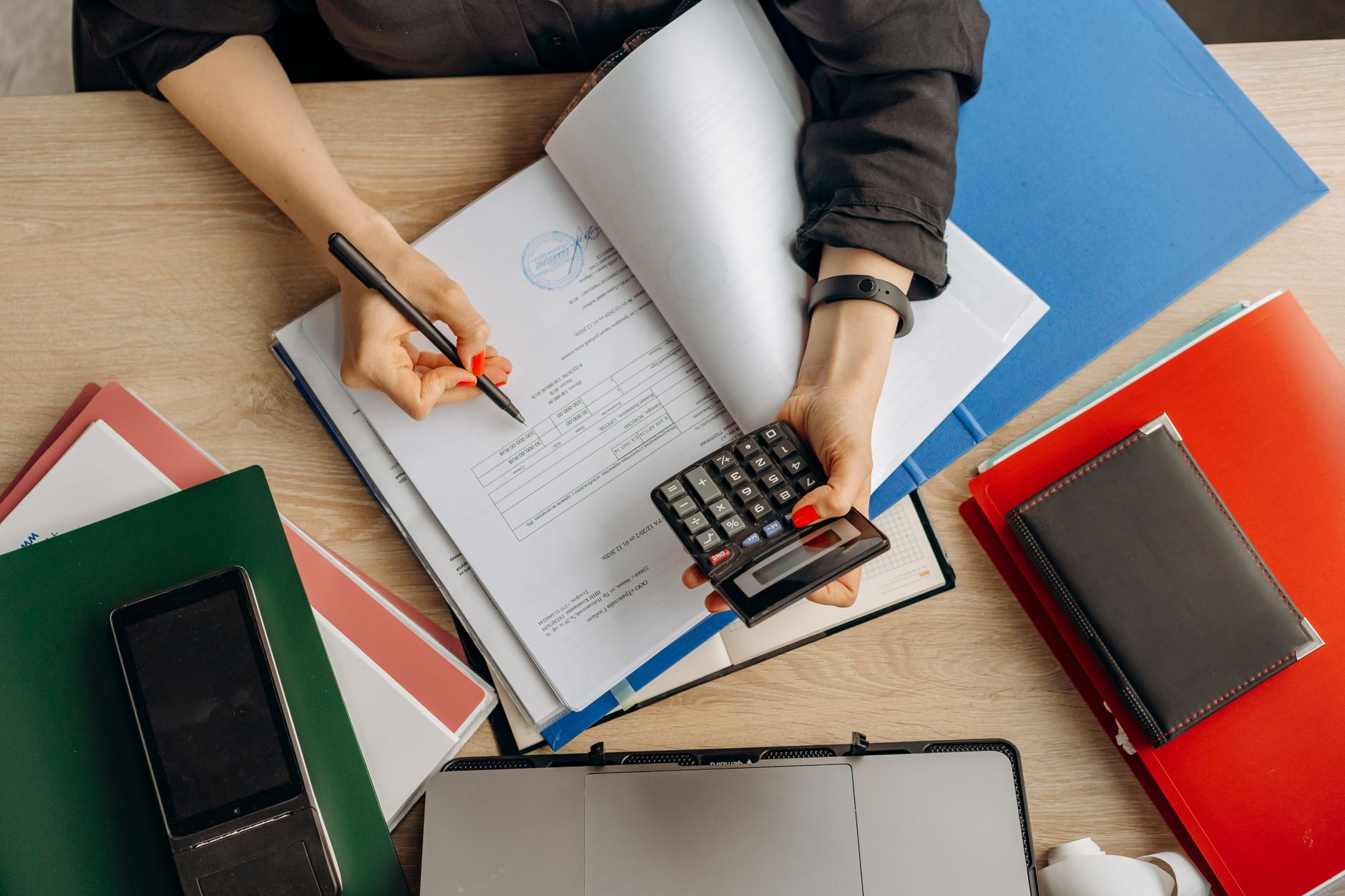 Qualifi Level 3 Diploma in Accounting and Finance — Accountant analyzing financial documents with a calculator on a desk, highlighting business tasks.