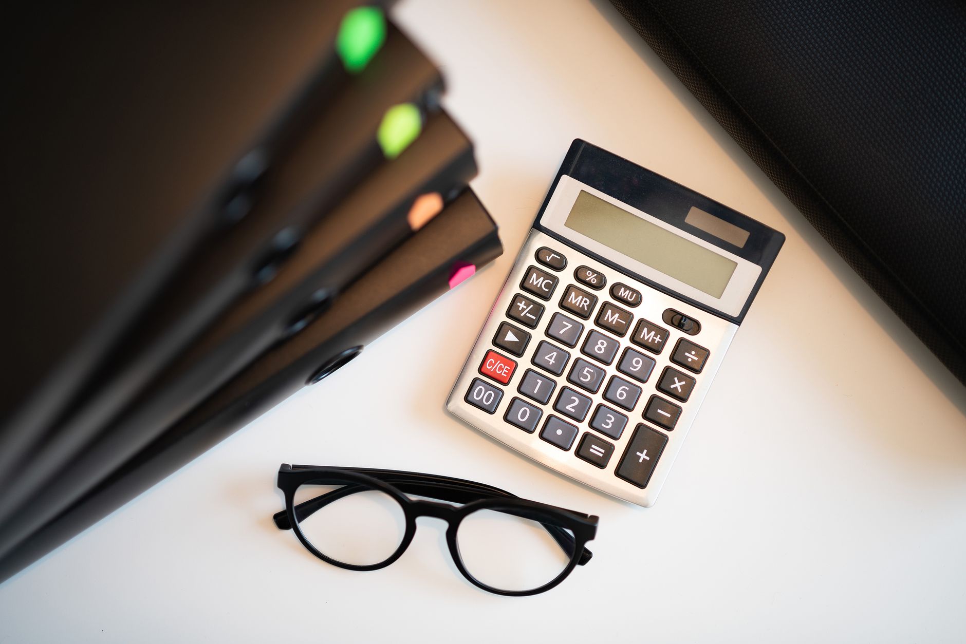 Qualifi Level 4 Diploma in Accounting and Finance — Calculator with glasses and folders on an office desk. Perfect for finance and accounting themes.