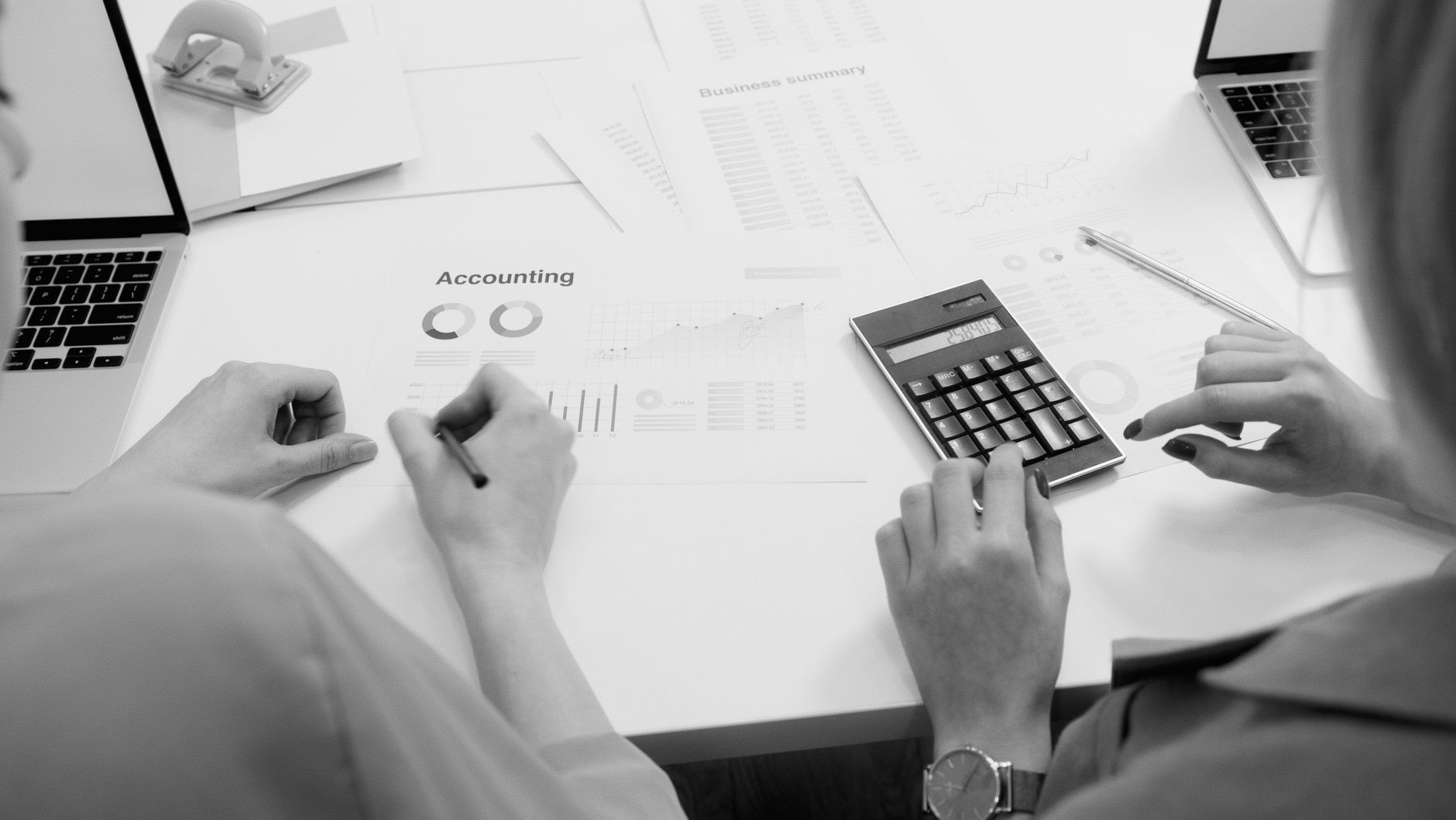 Qualifi Level 5 Diploma in Accounting and Finance — Black and white office scene featuring accounting documents, calculator, and laptops.