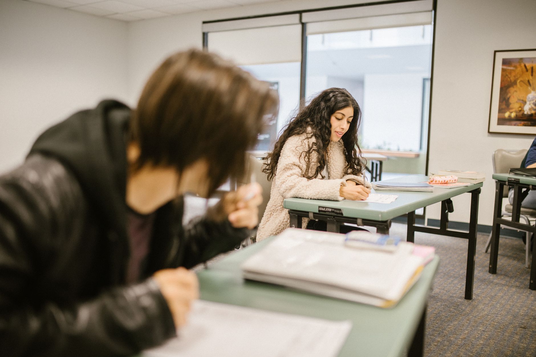 Qualifi Level 5 Extended Diploma in Law — Two students focused on an exam in a classroom setting during daylight.