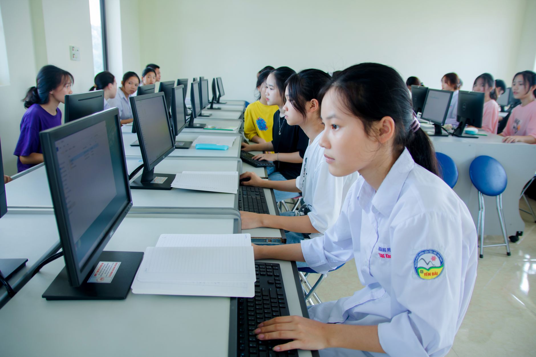 Qualifi Level 3 Diploma in Information Technology — Students engaged in study at a computer lab, focused on technology and teamwork.