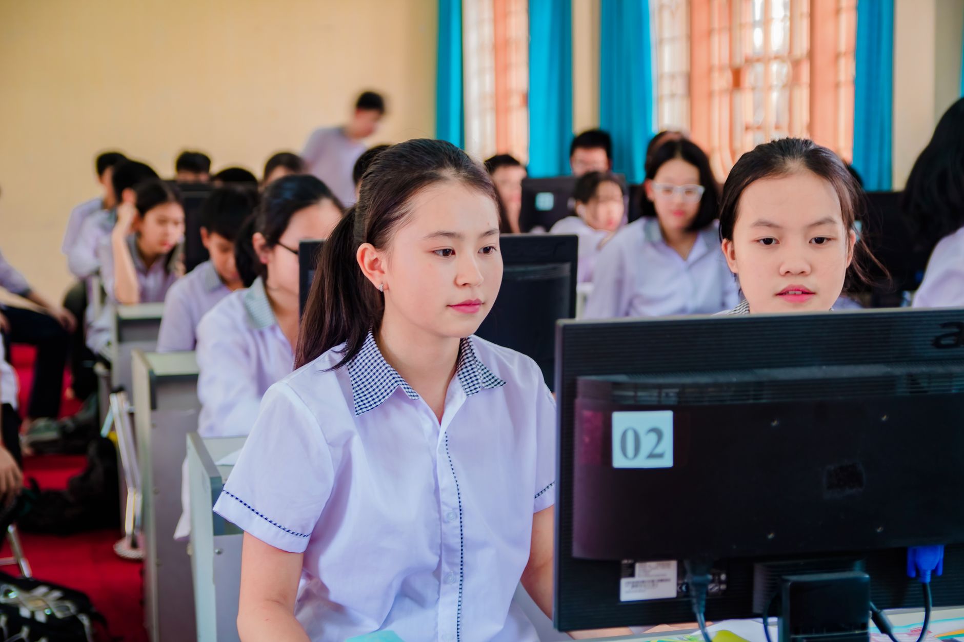 Qualifi Level 4 Diploma in Information Technology — Group of high school students focused on learning in a computer lab setting.