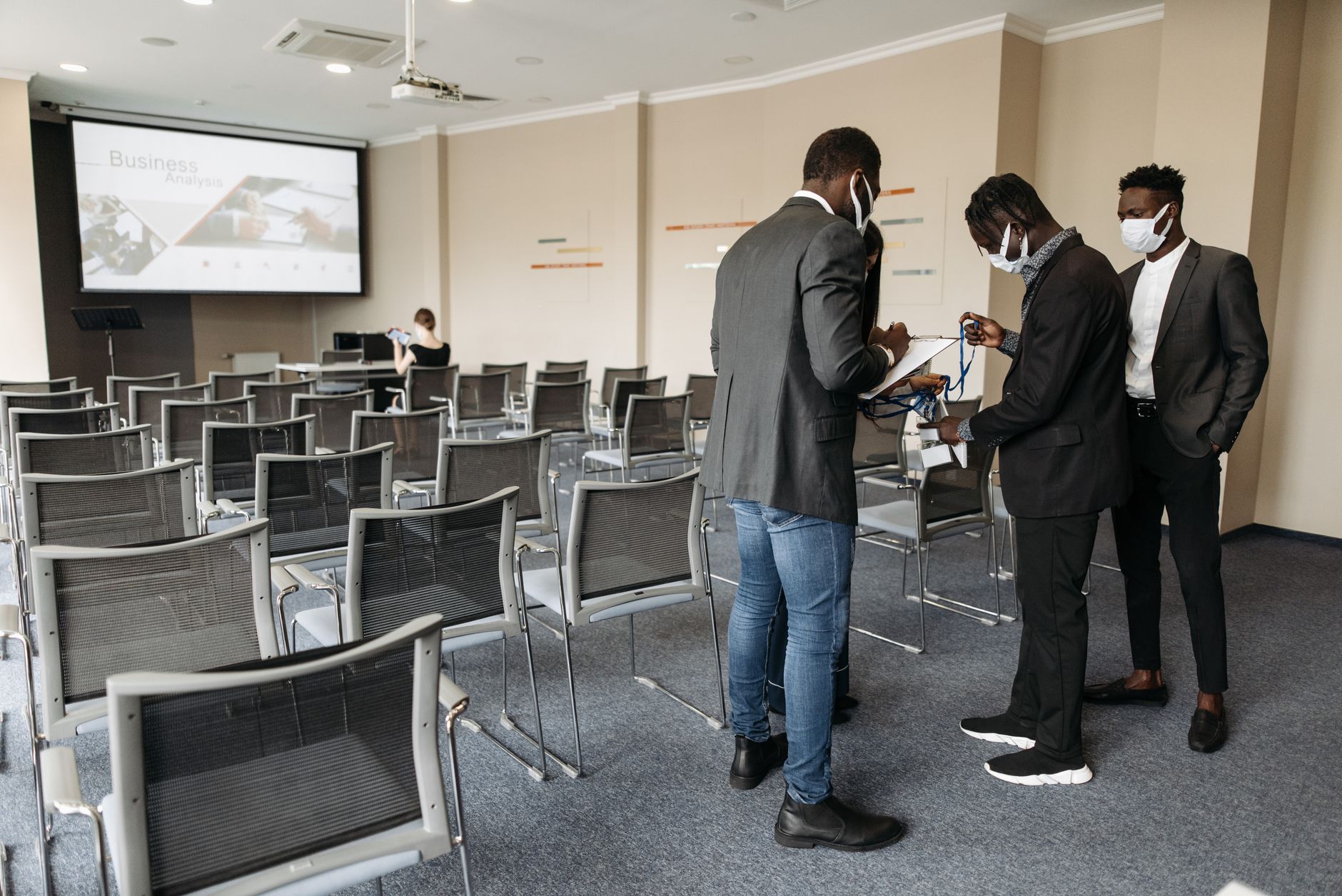 Understanding Health and Safety in the Business Workplace — Group of professionals in a conference room adhering to safety protocols during a presentation.