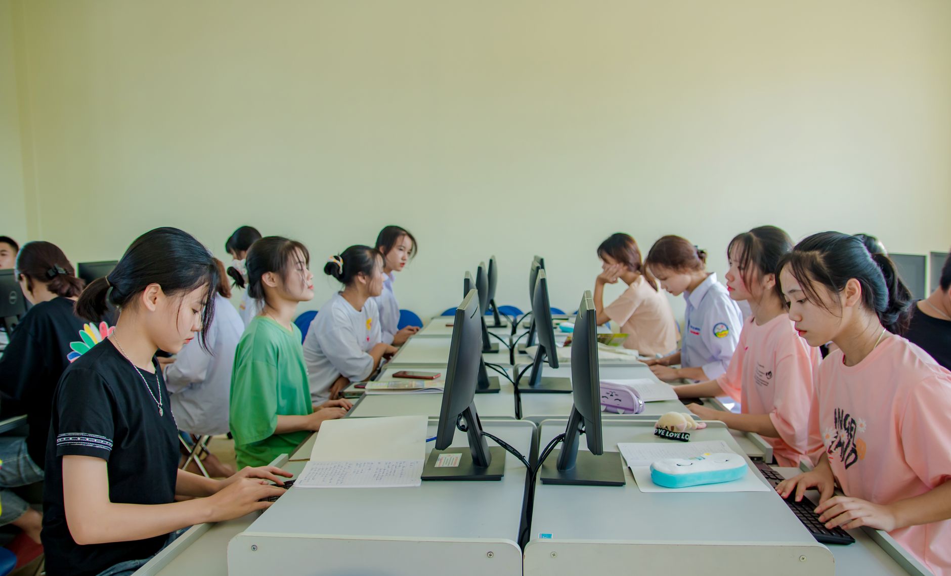 Computer Systems — Group of female students studying at computers in a classroom setting.