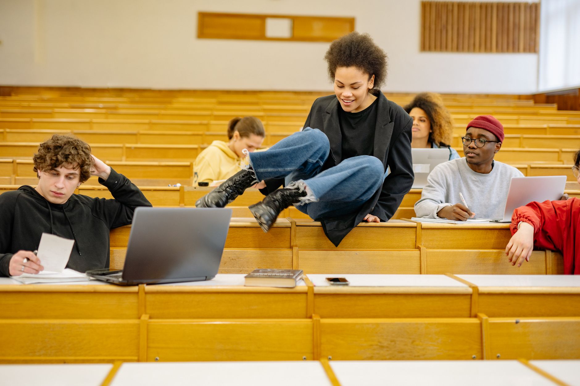 Units — Diverse students interact and study in a university lecture hall.
