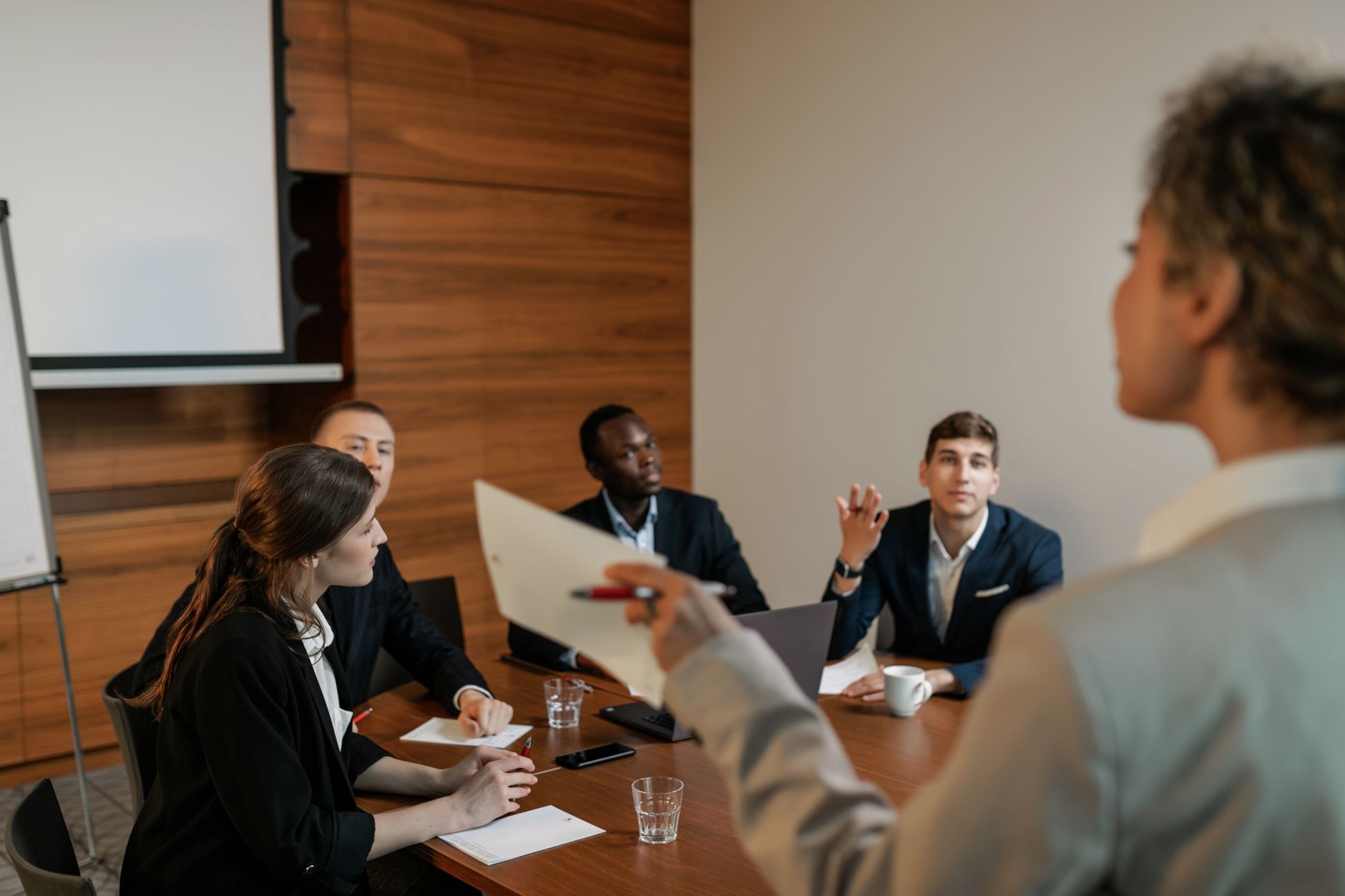 Human Resource Management — Professional business team engaged in a discussion in a modern conference room setting.