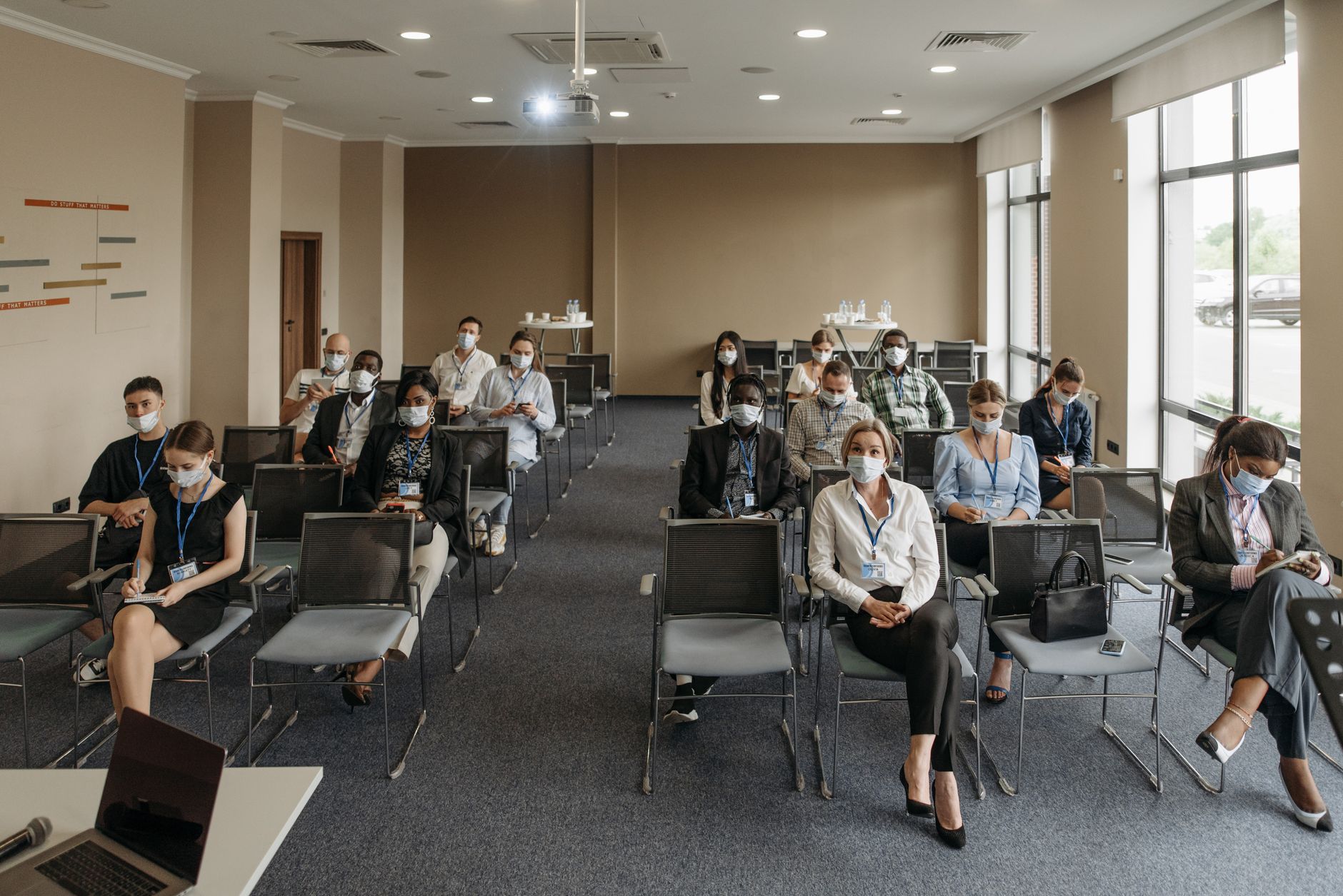 Understanding Health and Safety in the Business Workplace — Attendees wearing masks in a socially distanced setup during a business meeting to ensure safety.