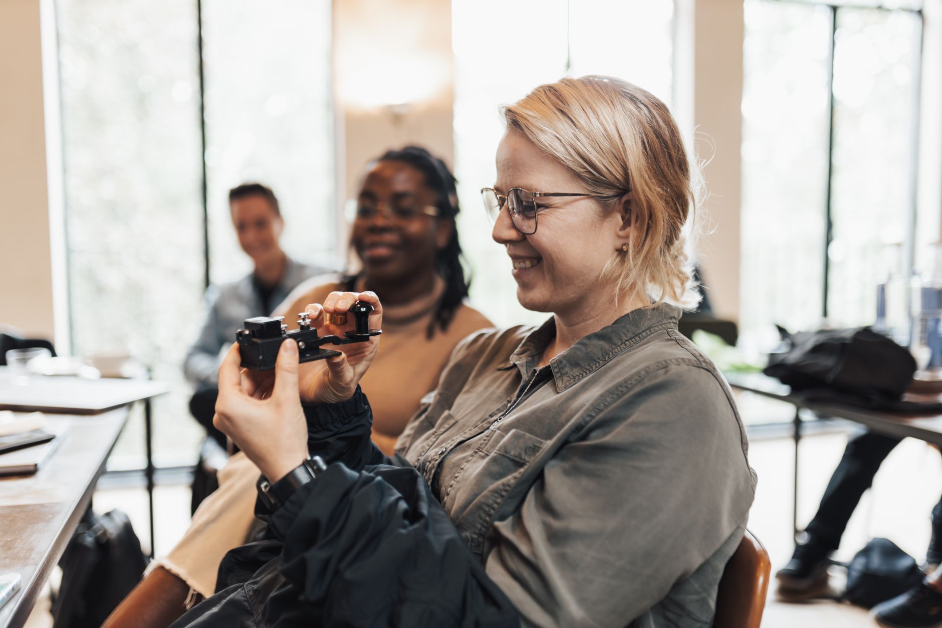 Future Foresight — A woman smiles while holding a virtual reality device in a bright indoor setting, focusing on technology.