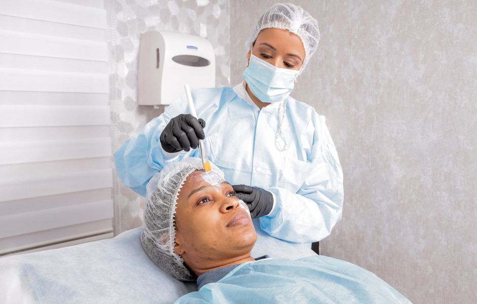 Qualifi Level 6 Award in Advanced Aesthetic Procedures: Chemical Peels — A beautician applies a treatment to a woman's face in a spa, focusing on skincare.