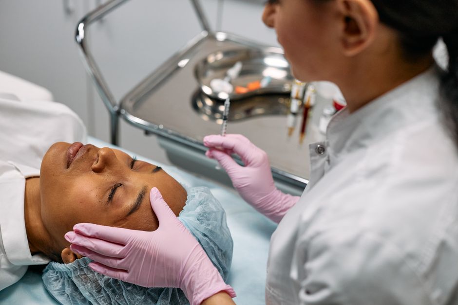 Qualifi Level 3 Certificate in Massage — Professional administering skincare treatment with syringe indoors.