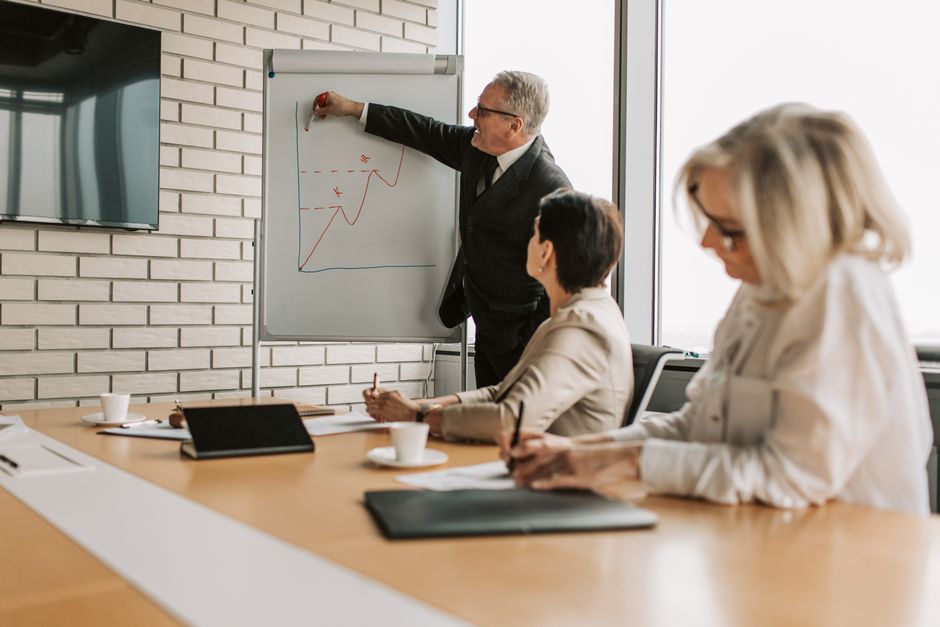 Academic Writing Skills — A group of professionals engaging in a business presentation in a stylish office setting.
