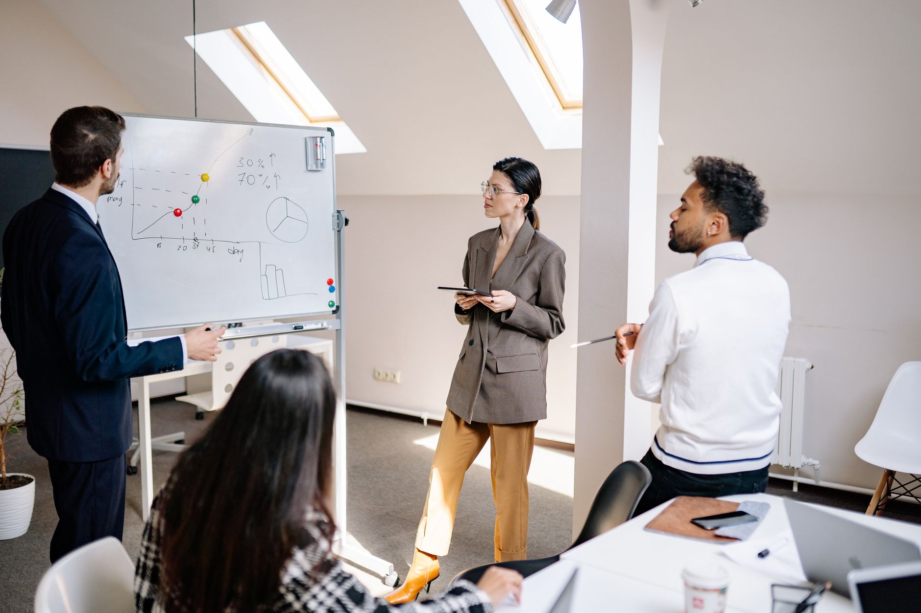 Risk Management and Organisations — Professionals engaged in a collaborative team meeting with charts for strategy planning.