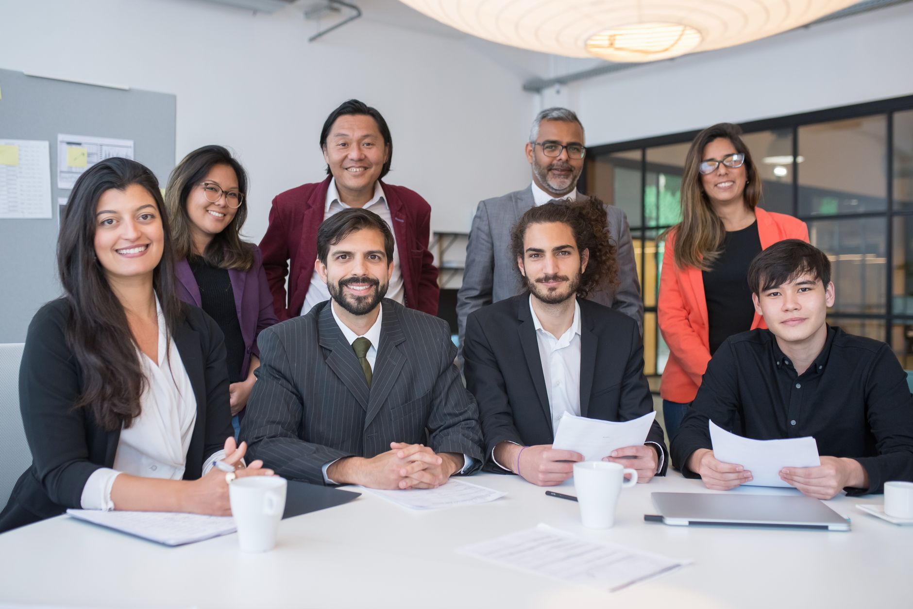 Strategic Marketing Management — A multicultural business team collaborating in a modern office meeting room.
