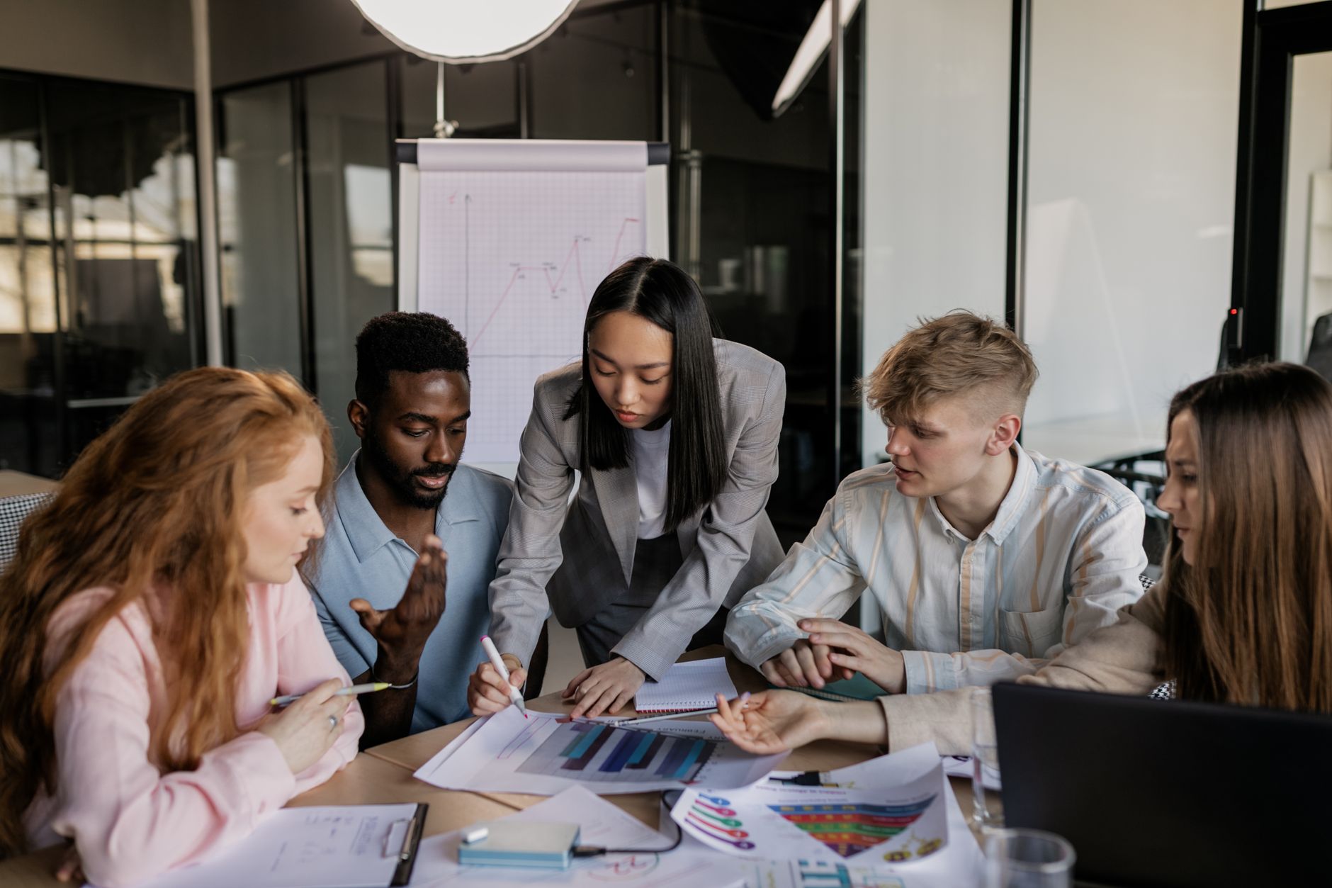 Strategic Marketing — A diverse group of professionals engaged in a collaborative business strategy meeting in a modern office.