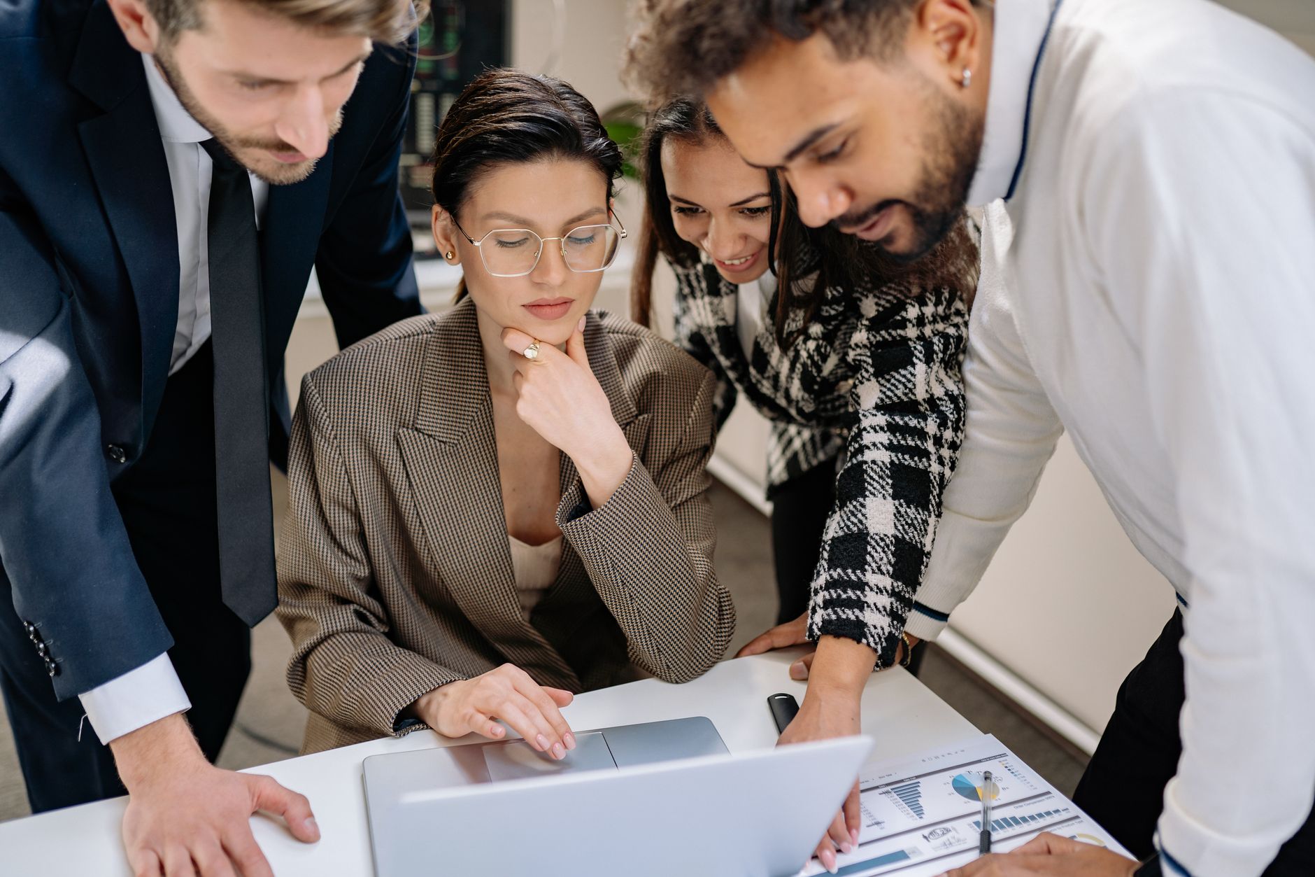 Development as a Strategic Manager — Business team collaborating around a laptop in a modern office environment.