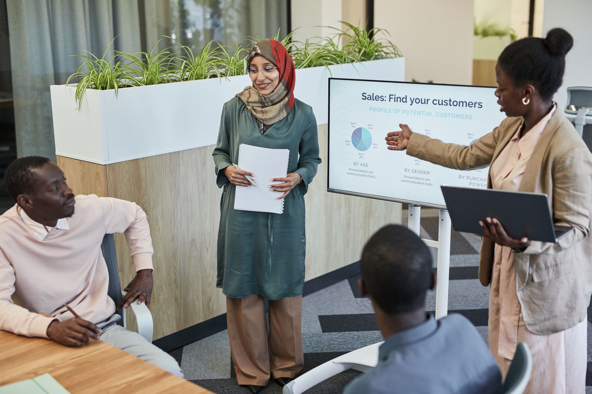 Customer Growth marketing — Team of professionals discussing sales strategy during a business presentation in a modern office.