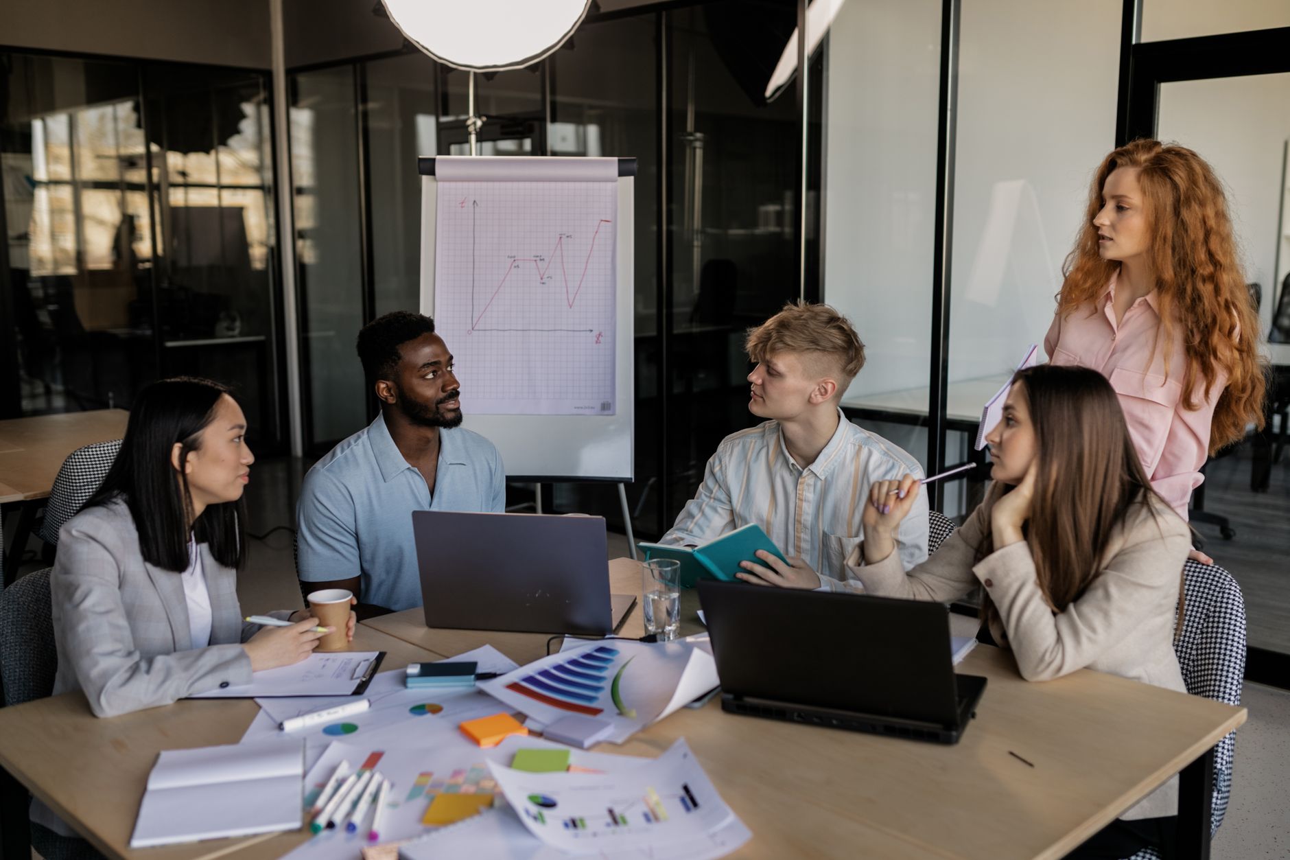 Contemporary Issues Underpinning Leadership in CPDDeveloping Research and CPDEffective Communication through CPD — A diverse team discussing business strategy around a conference table in a modern office.