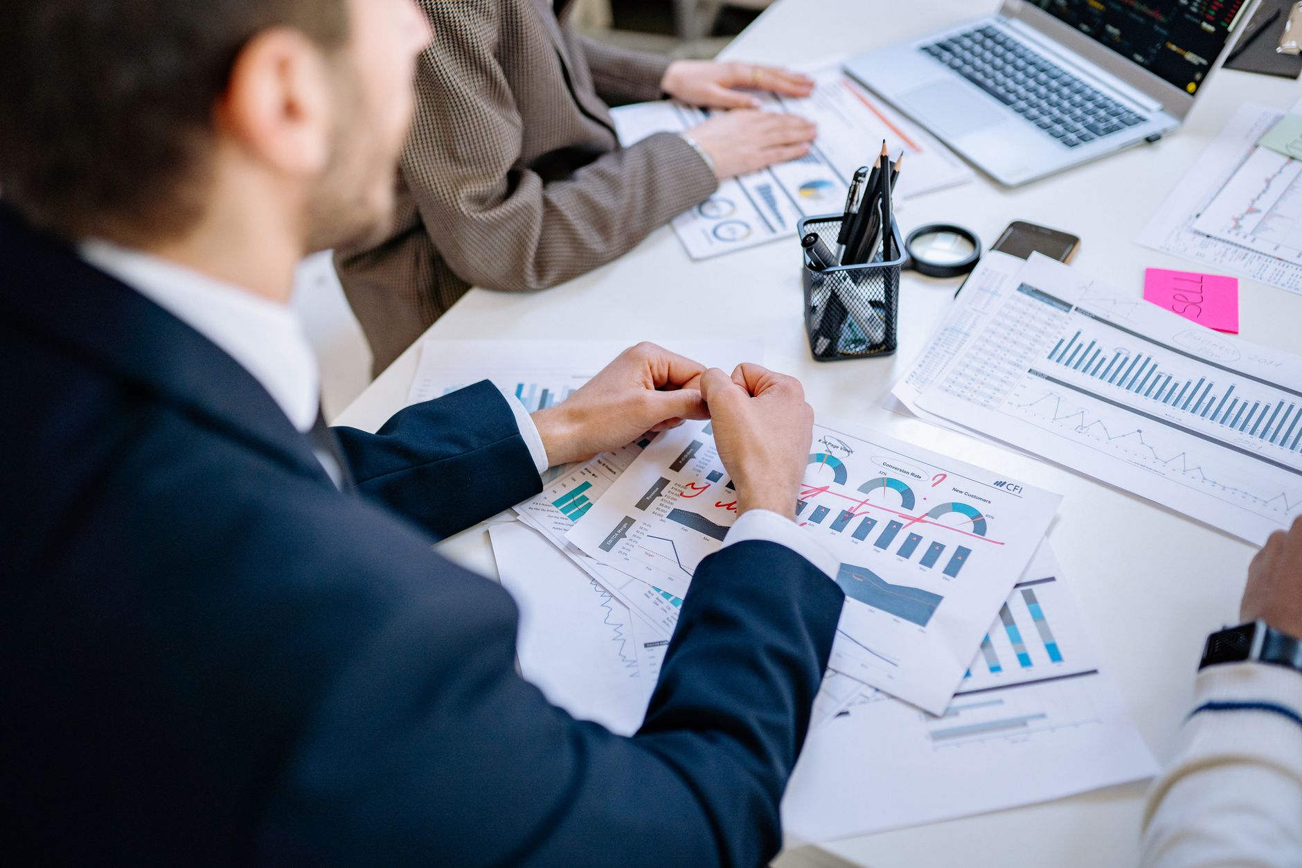 Corporate Finance and Financial Strategy — Business team analyzing financial graphs at a meeting table, fostering collaboration in an office environment.