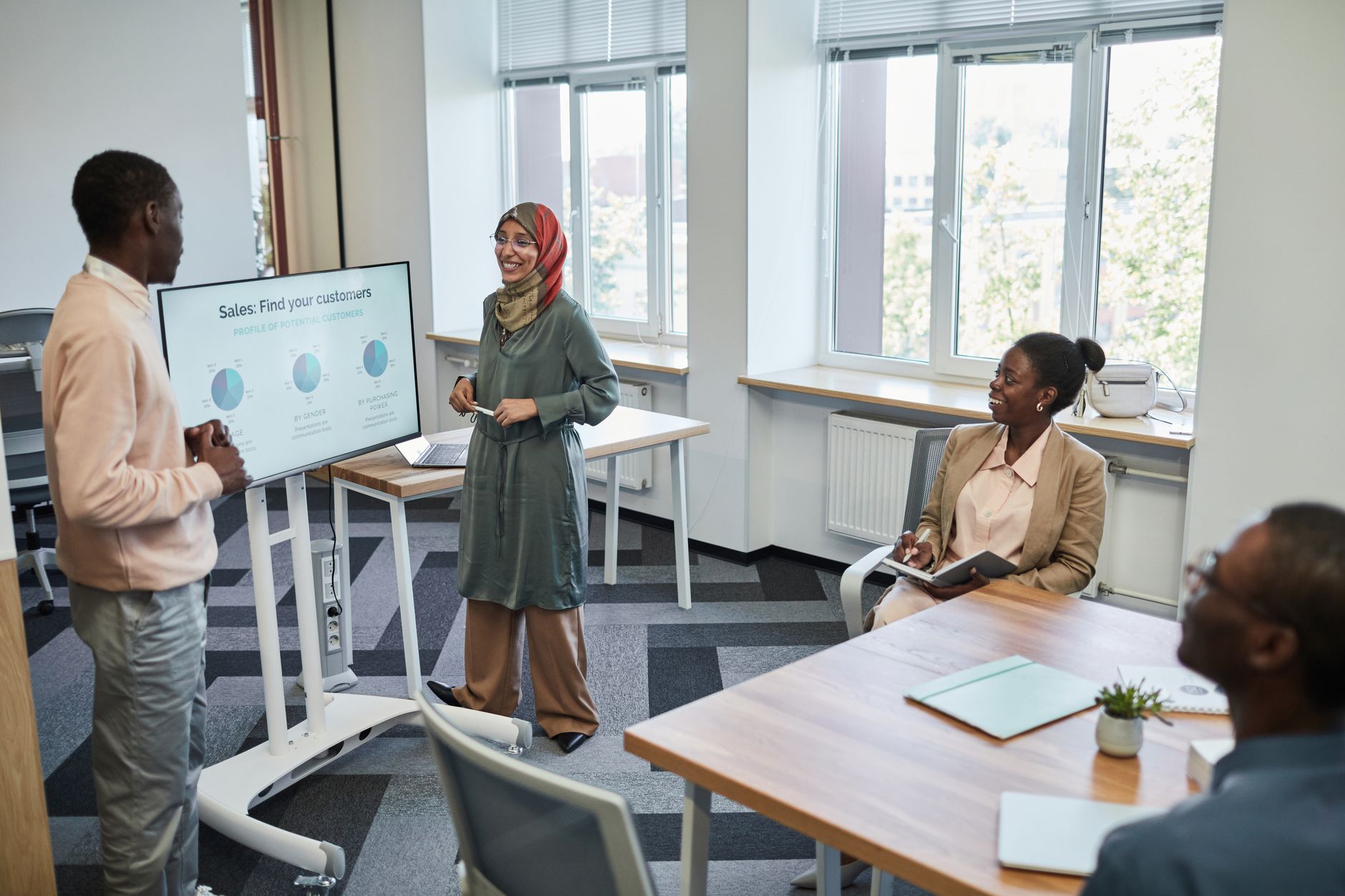 Strategic Marketing — Multicultural team having a business presentation in a modern office setting.