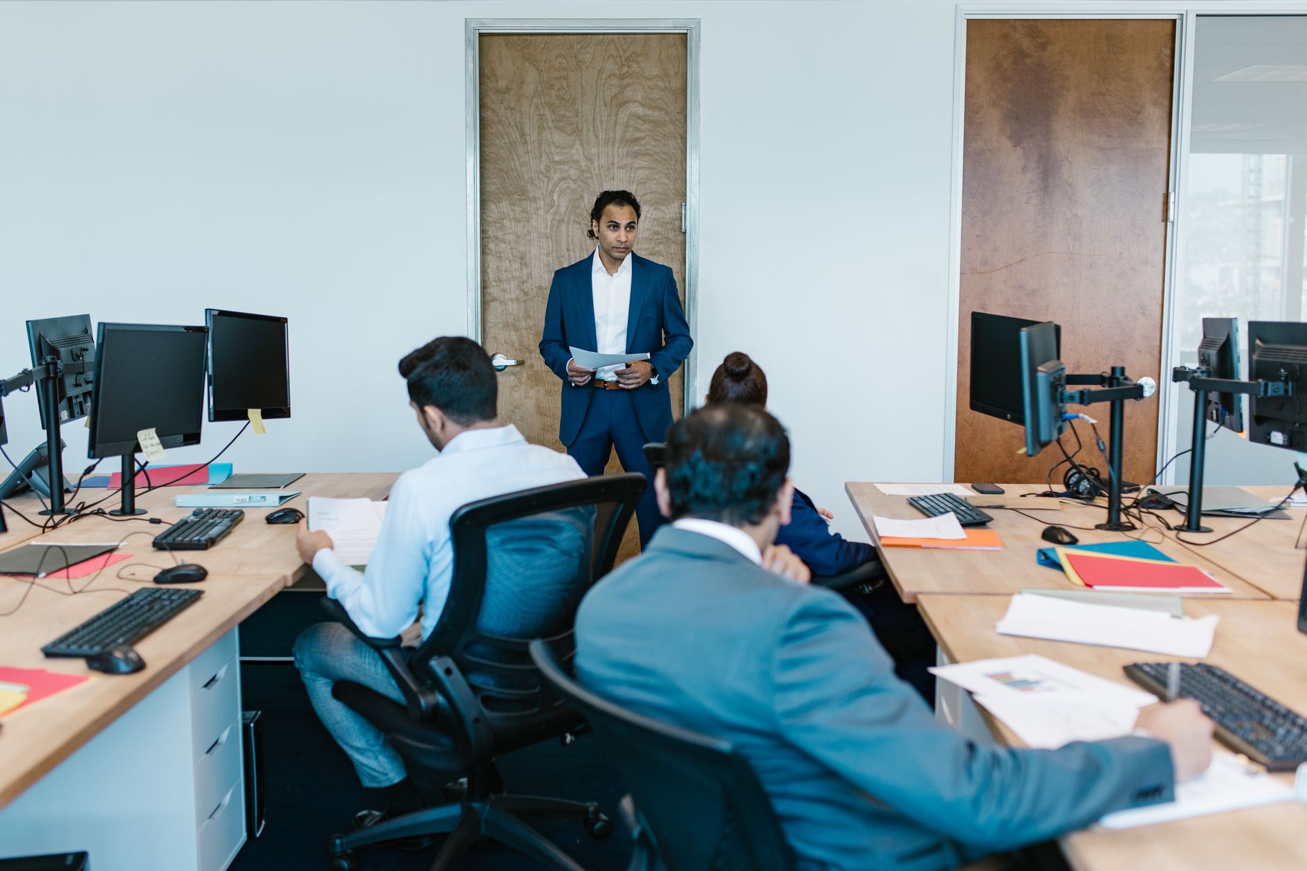 Strategic Direction — Business meeting with diverse team in modern office space, discussing projects.