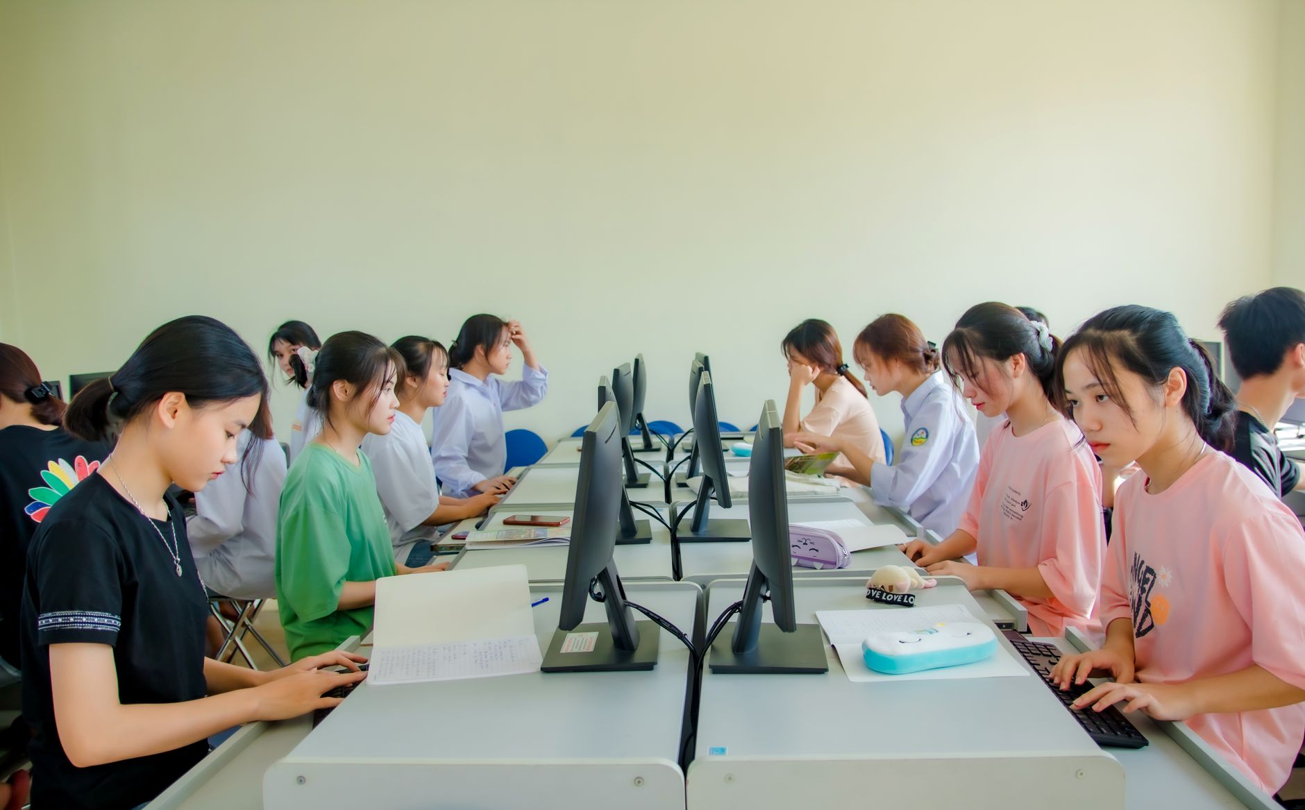Leadership Qualities and Practice — A group of students in a classroom using computers for team learning activities.