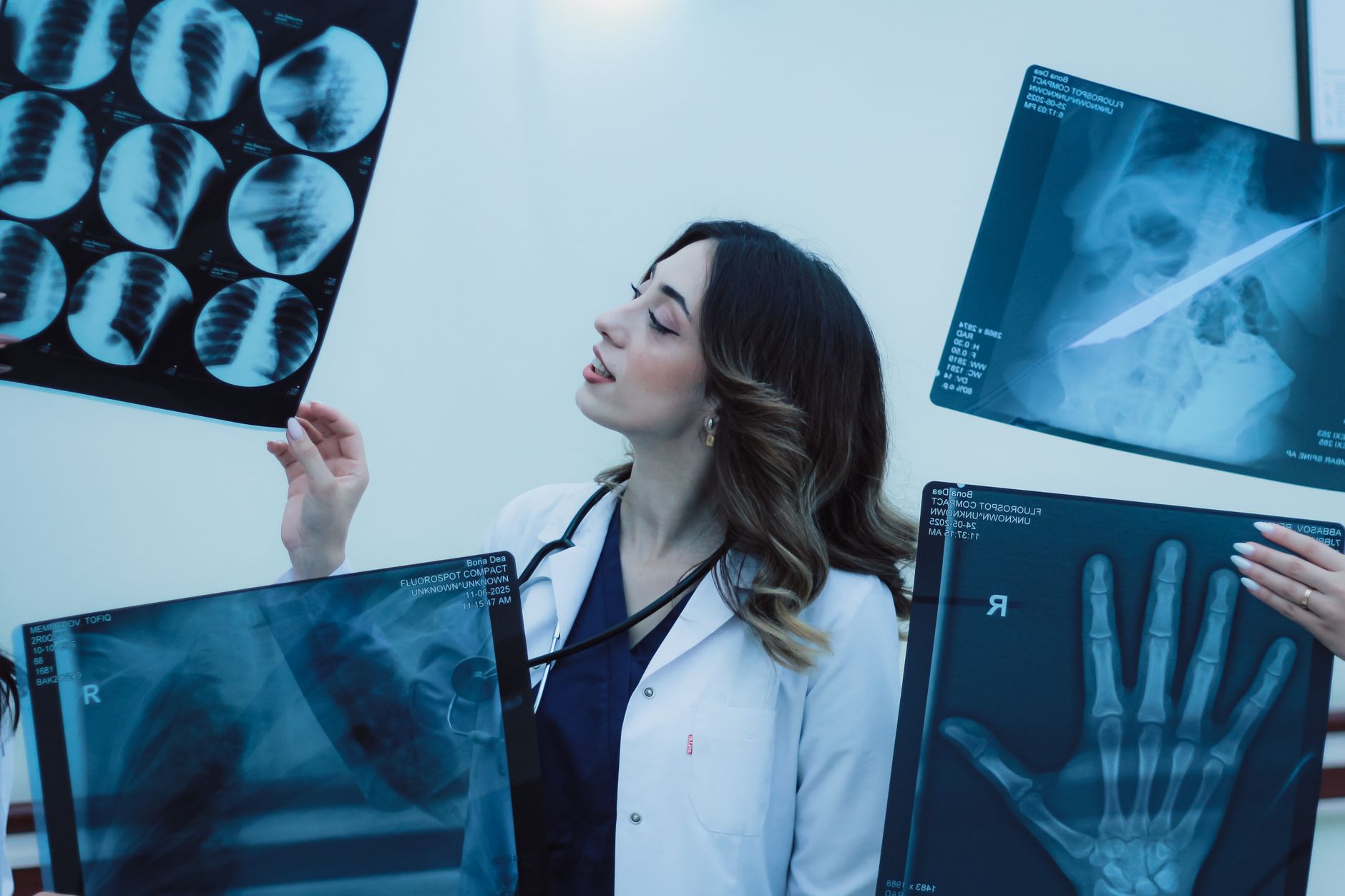 Personal Development in a Care Setting — Female doctor examining x-rays in a clinical setting, showcasing medical expertise.
