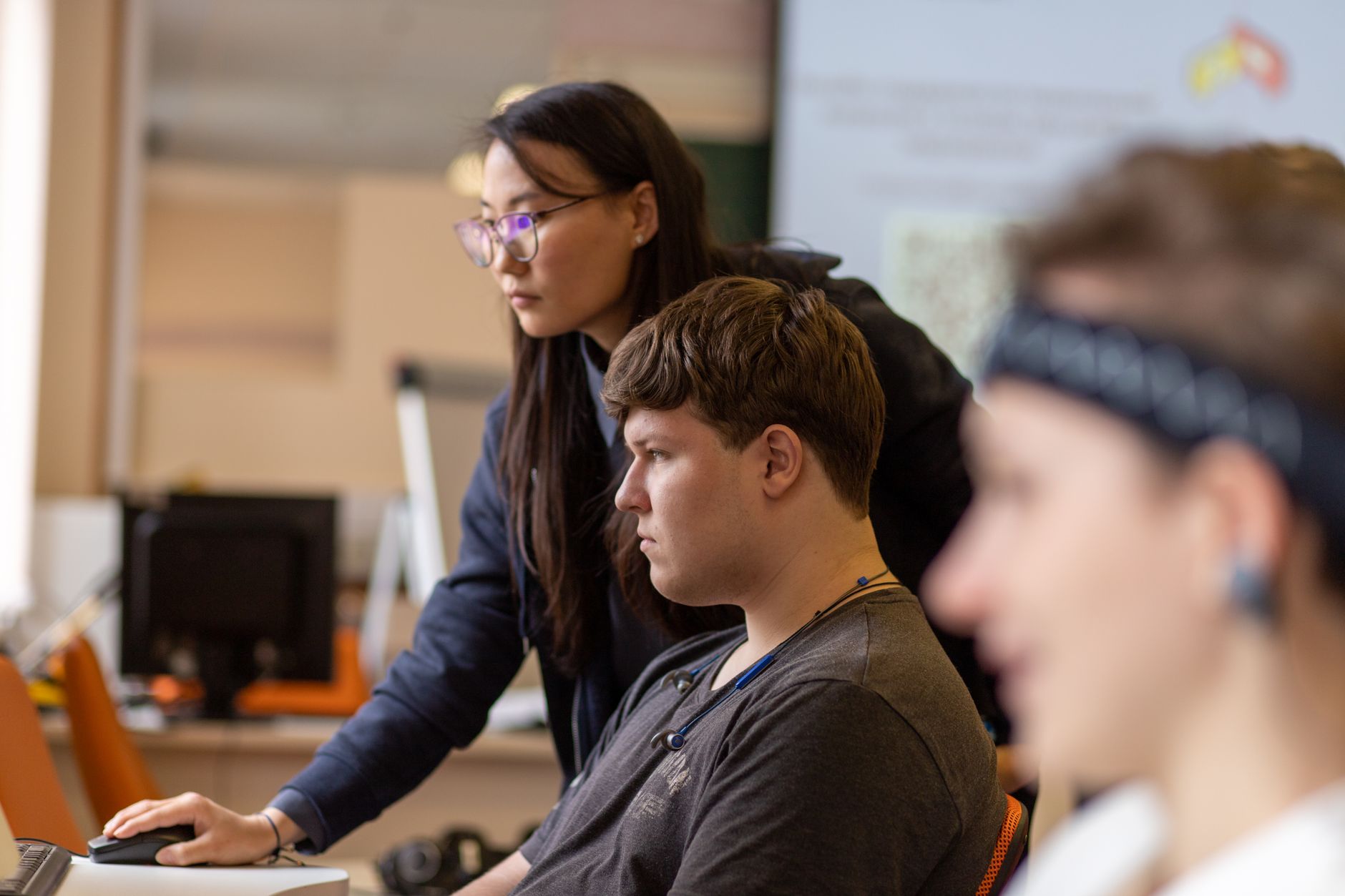 Understand the Context of Supporting Individuals with Learning Disabilities — Students working together on computers in a classroom, showcasing diversity and teamwork.