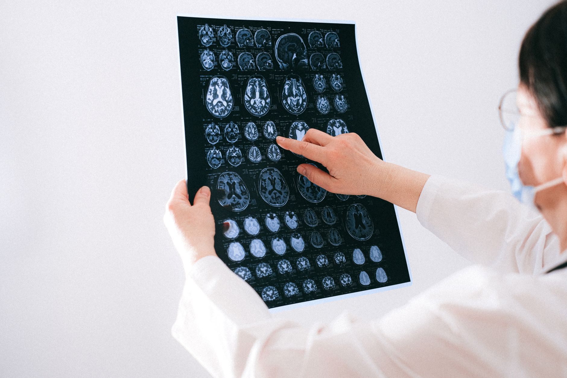 Understand the Impact of Acquired Brain Injury on Individuals — Doctor examines brain mri scans closely for medical diagnosis in a hospital environment.