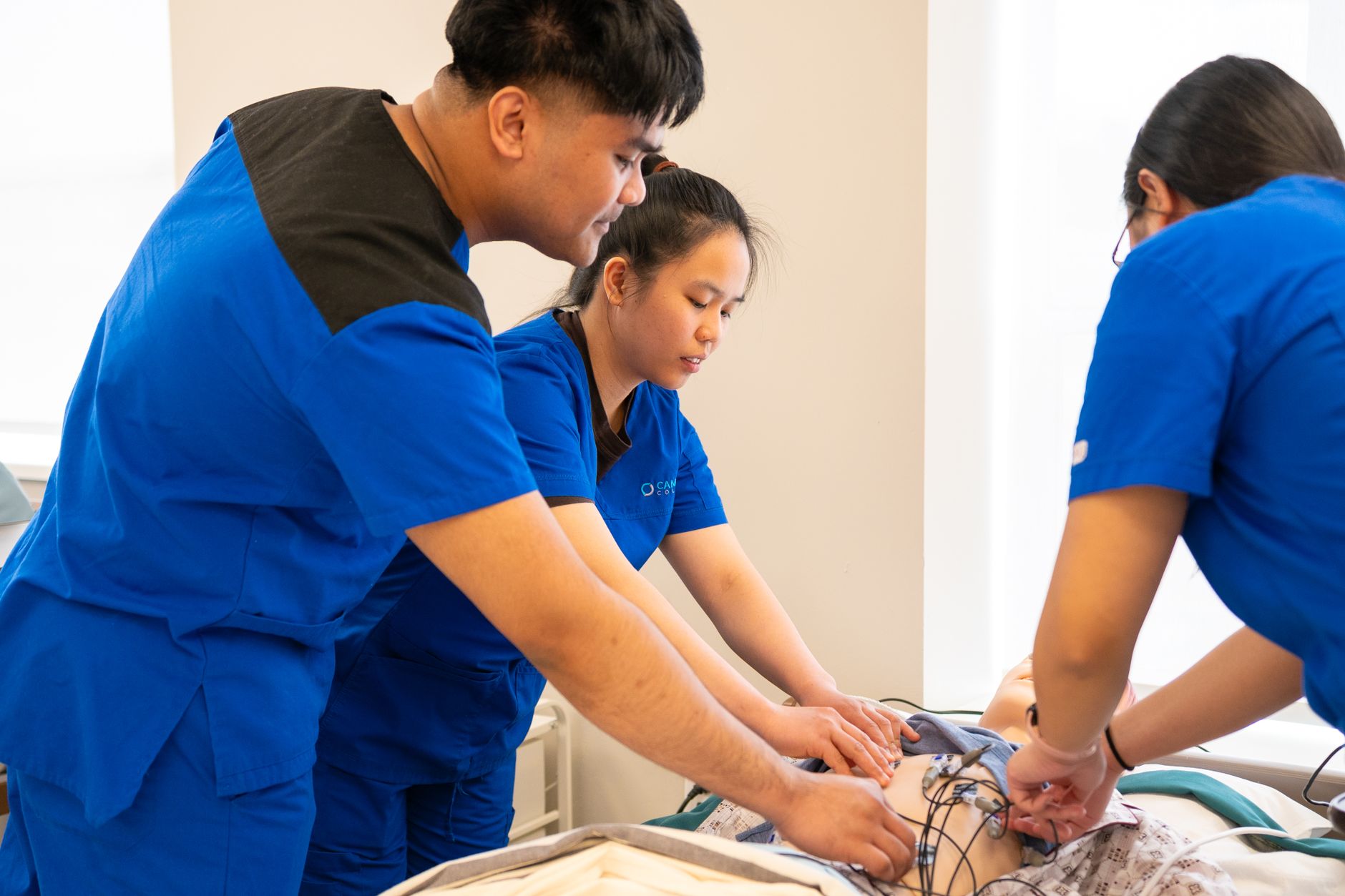 Understand Own Role — Group of nursing students conducting a medical procedure in a training room.
