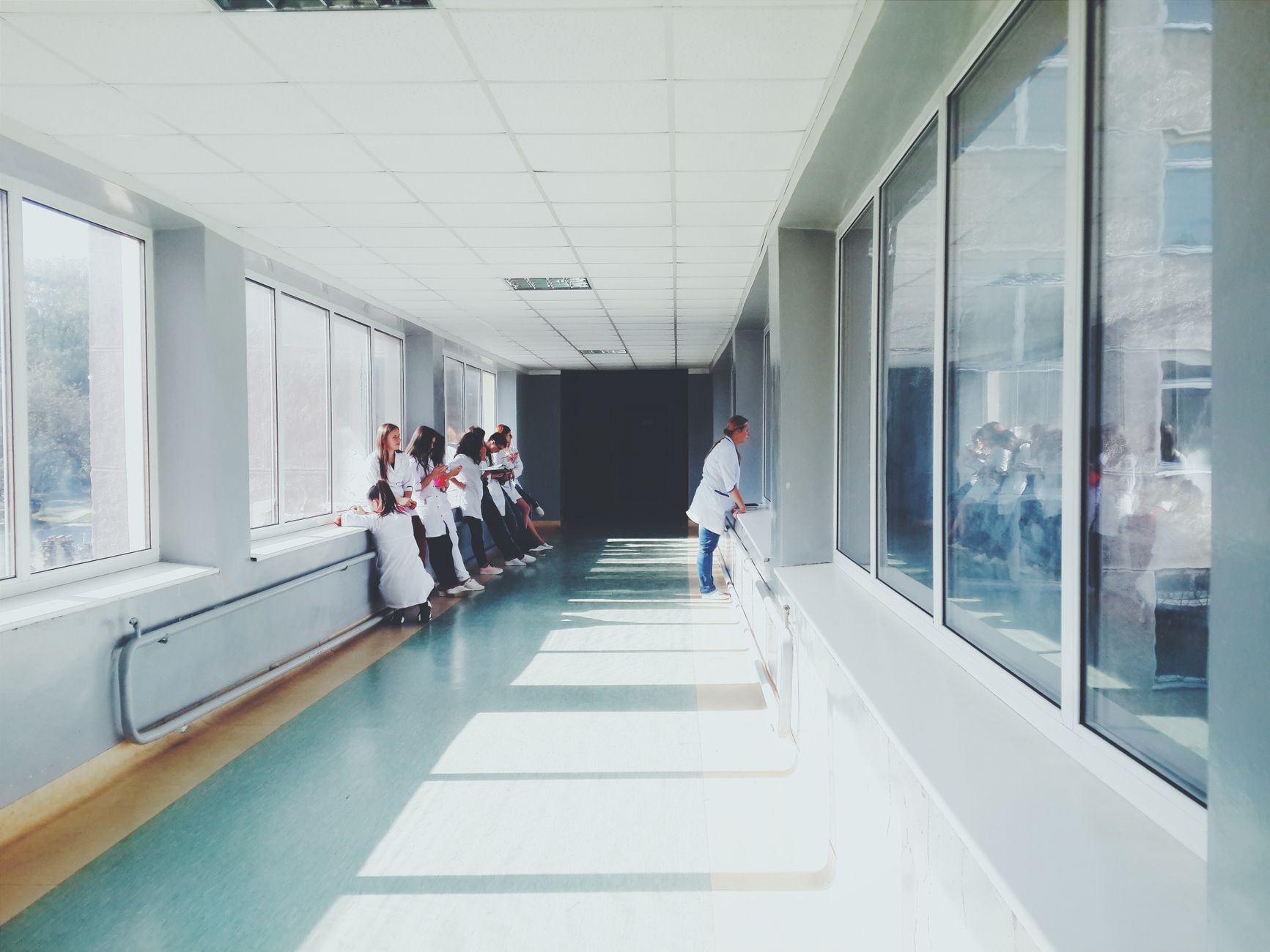 Personal Development — A brightly lit hospital hallway with medical staff in white coats, conveying a professional healthcare environment.