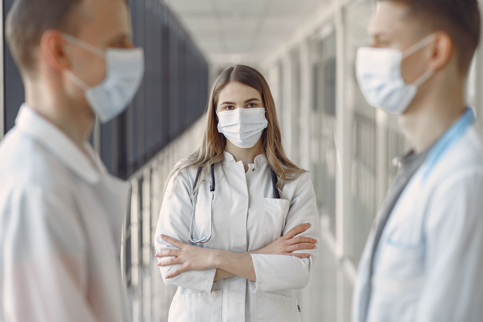 Work in a Person-centred Way — Medical professionals wearing face masks in a hospital hallway.