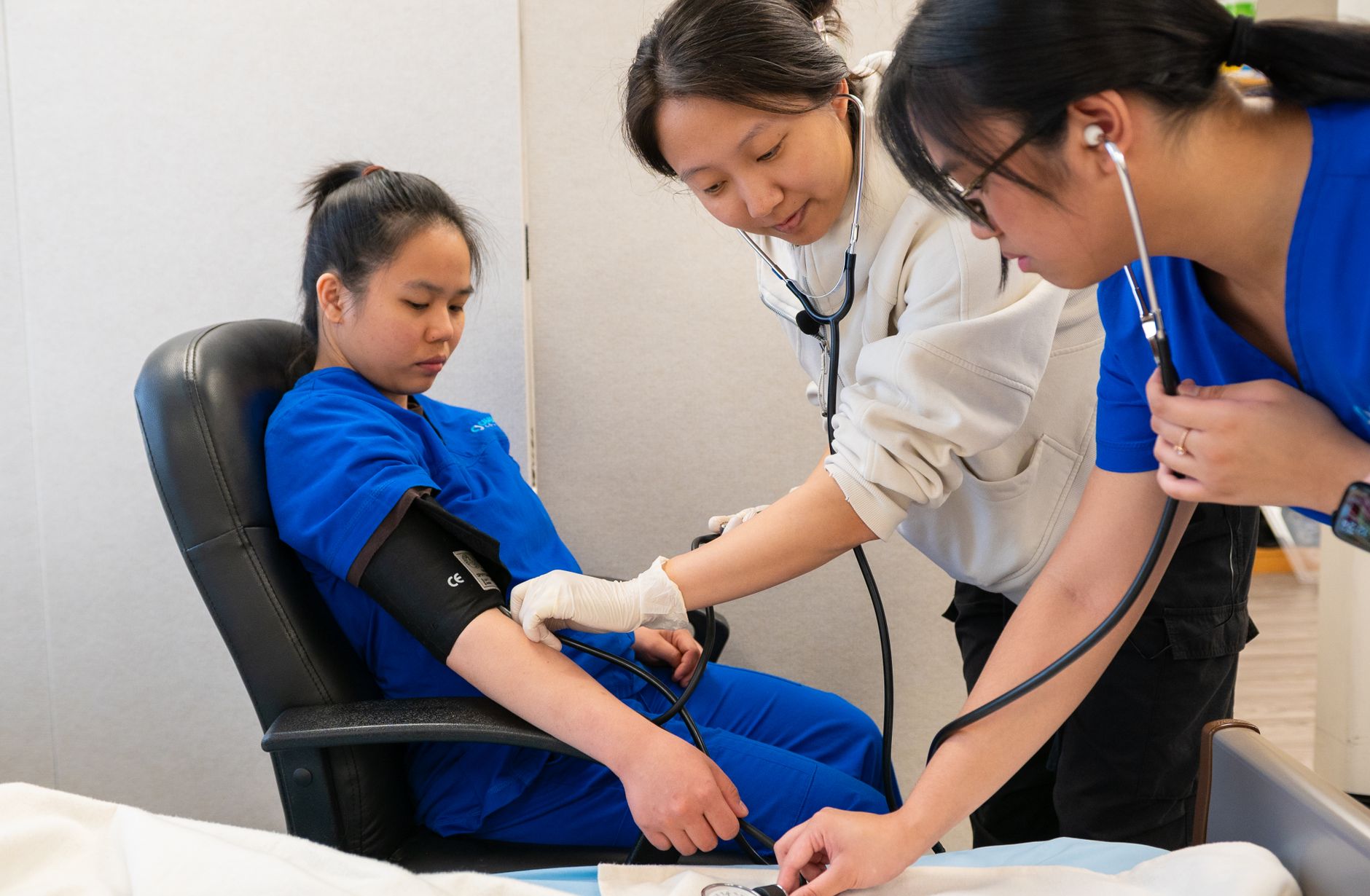 Safeguarding Children — Healthcare professionals conducting a blood pressure check on a patient in a clinical setting.
