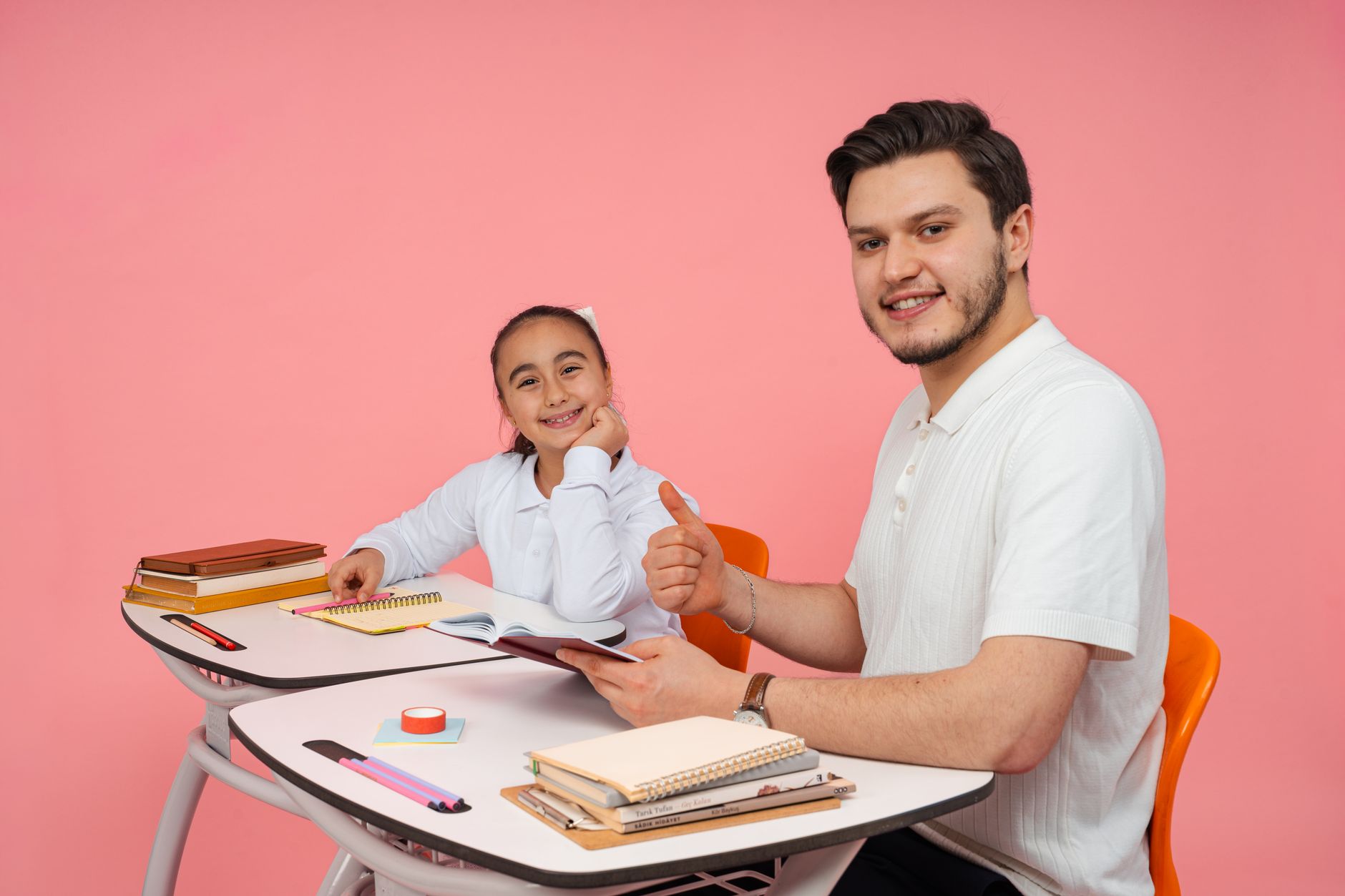 Academic Study Skills — A teacher and a student smiling together at a desk in a classroom environment.