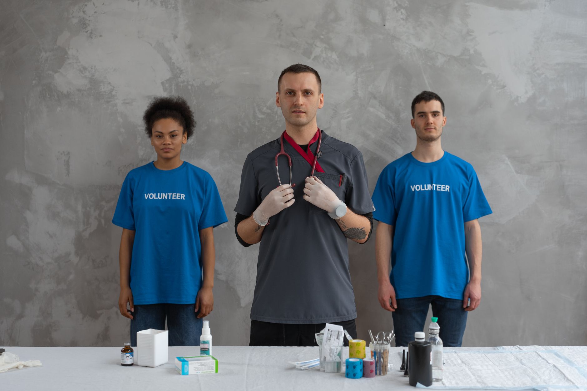 Managing People in Health and Social Care — Doctor with volunteers in a clinic, showcasing teamwork and healthcare support.