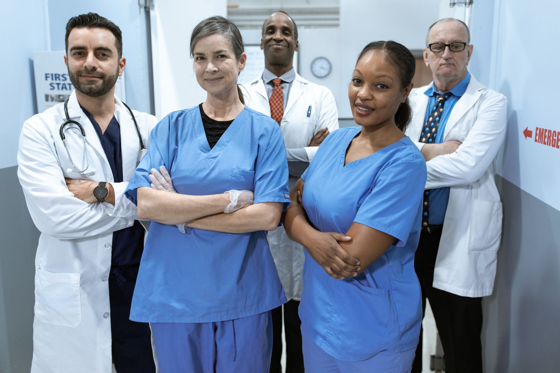 Managing People in Health and Social Care — A diverse team of doctors and nurses smiling confidently in a hospital setting.