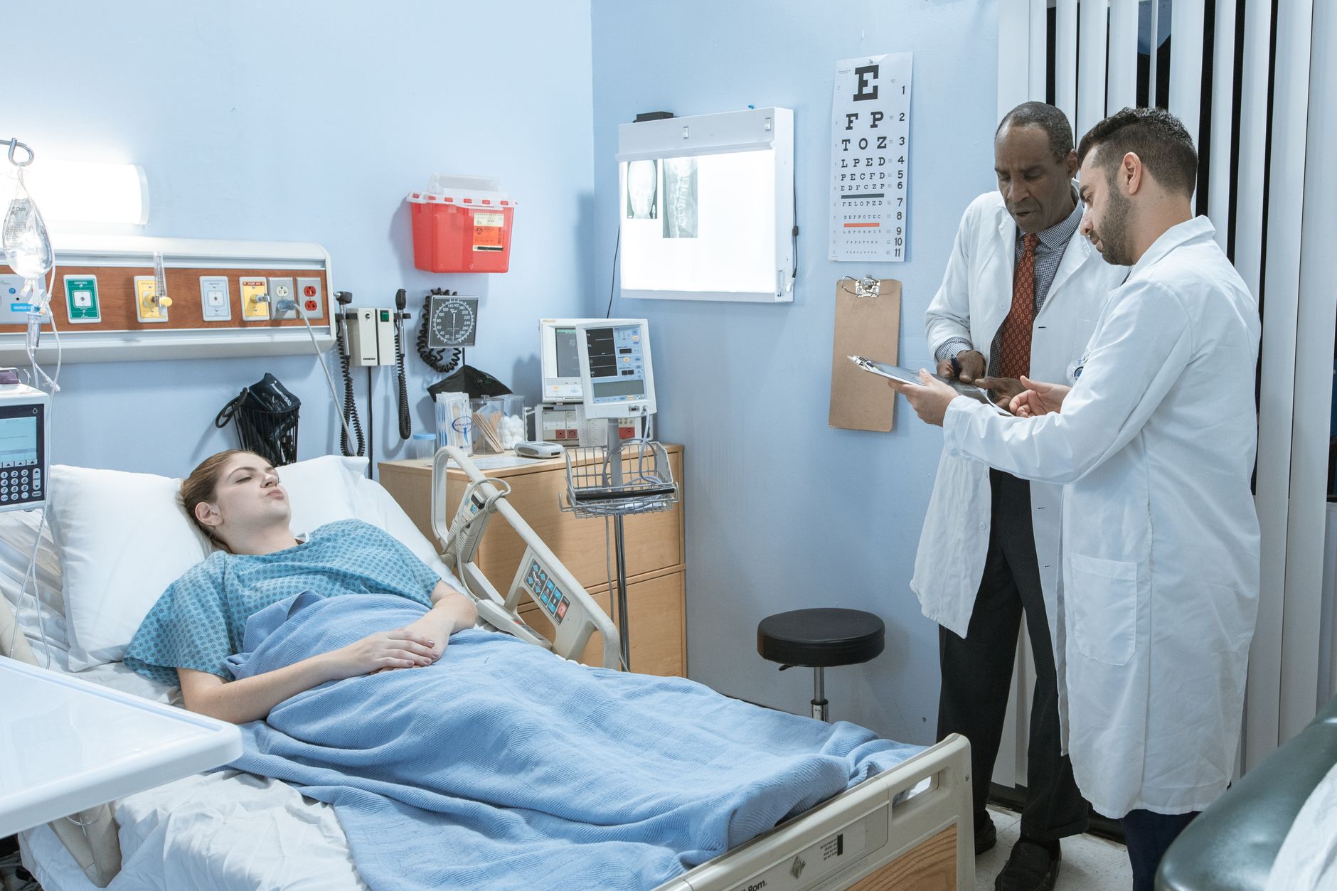 Sociology Concepts in Health and Ill Health — Medical professionals consulting over a patient's treatment in a hospital setting.